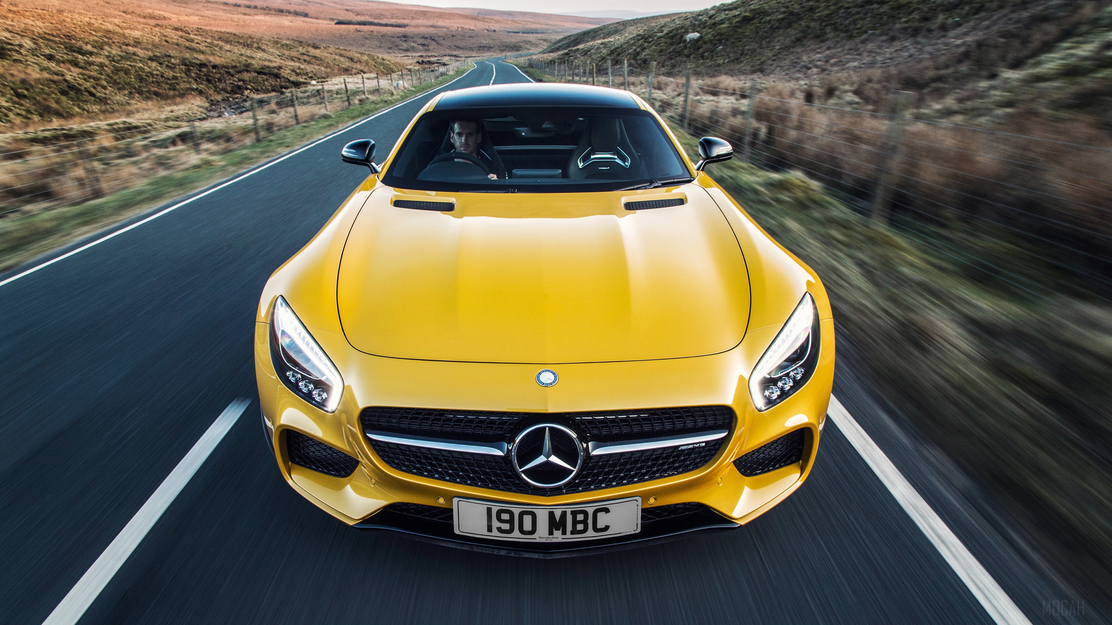 Yellow Mercedes-AMG GT driving on a road HD Wallpaper
