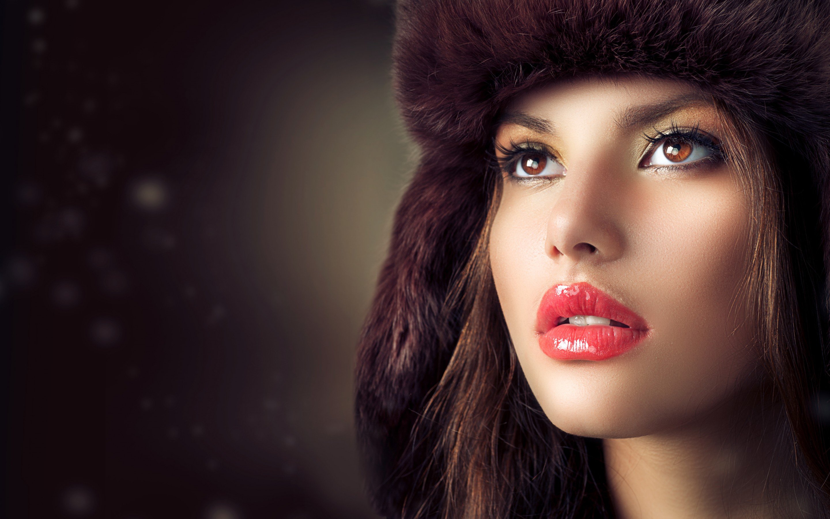 Woman wearing a fur hat with glossy red lips HD Wallpaper