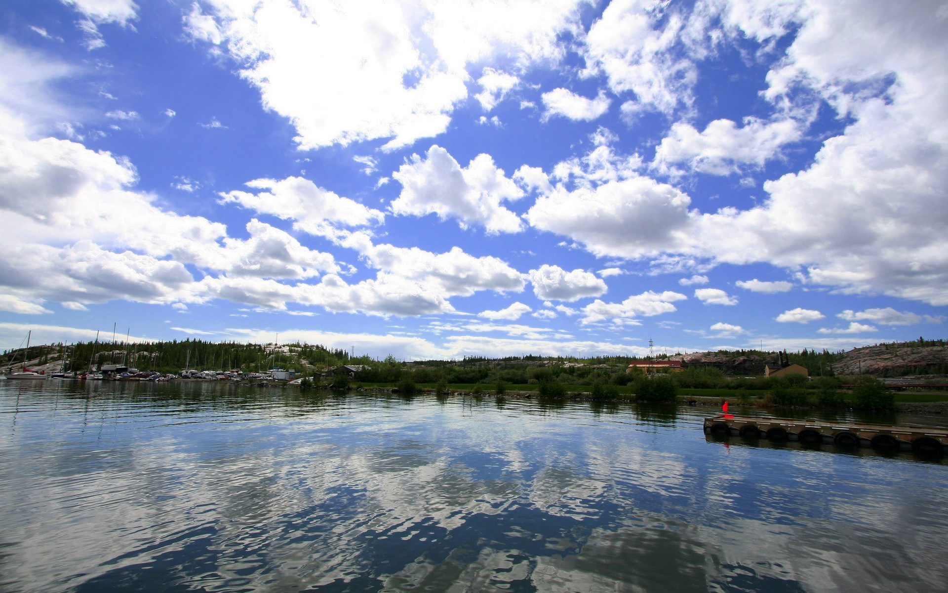 Boats docked on a lake with a cloudy blue sky HD Wallpaper