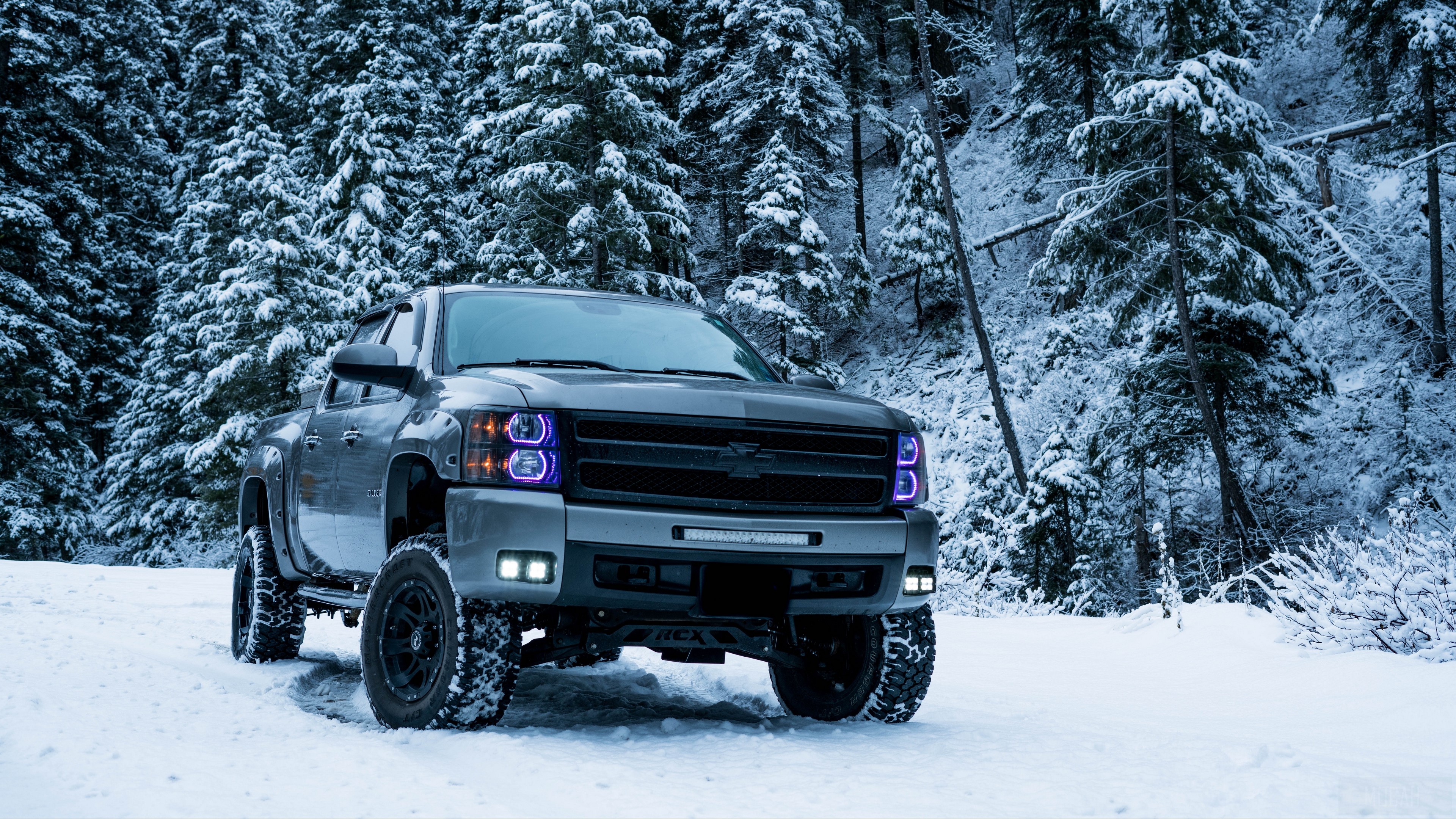Gray lifted pickup truck in snowy forest HD Wallpaper