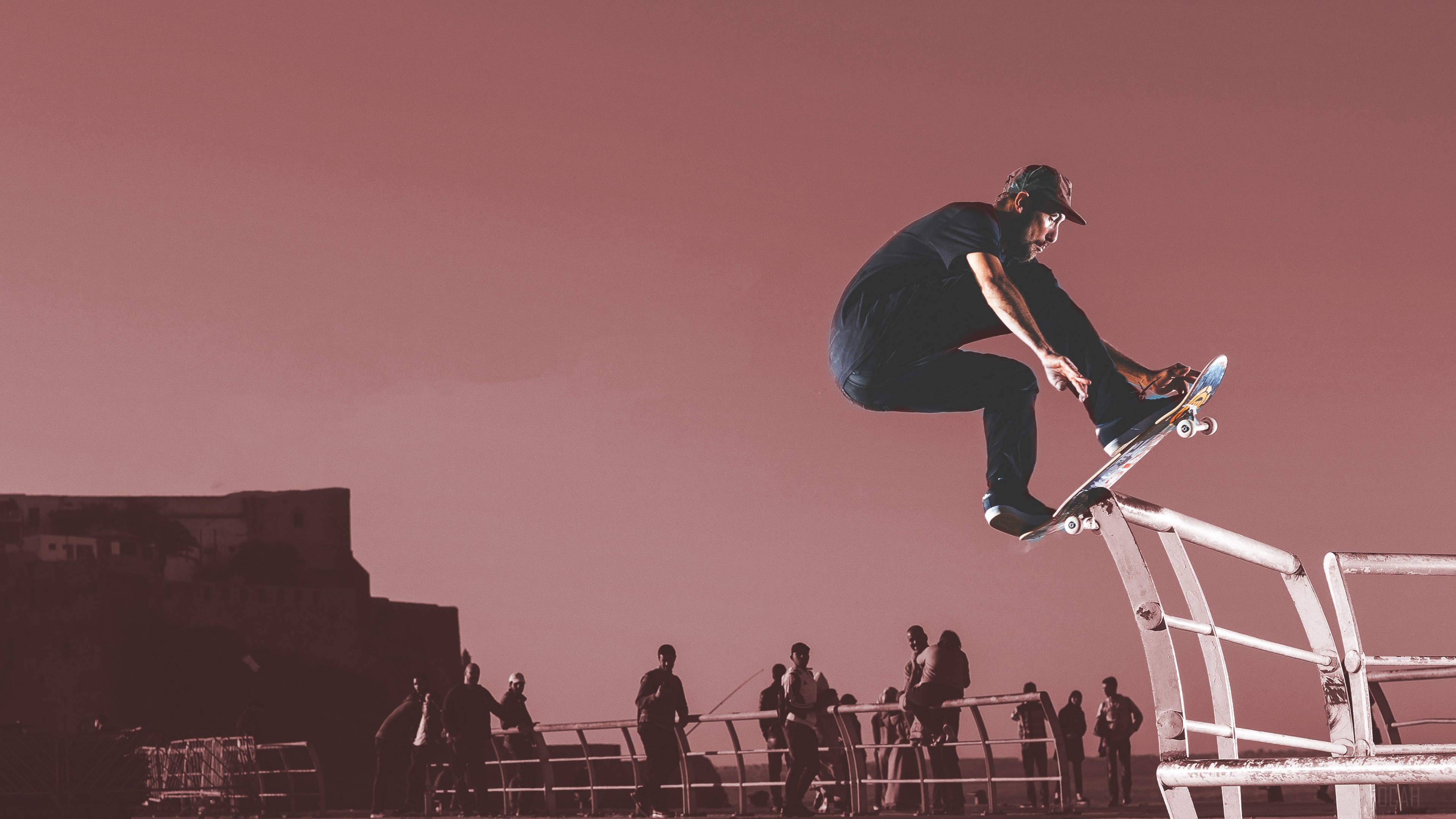Skateboarder performing a trick over a railing HD Wallpaper