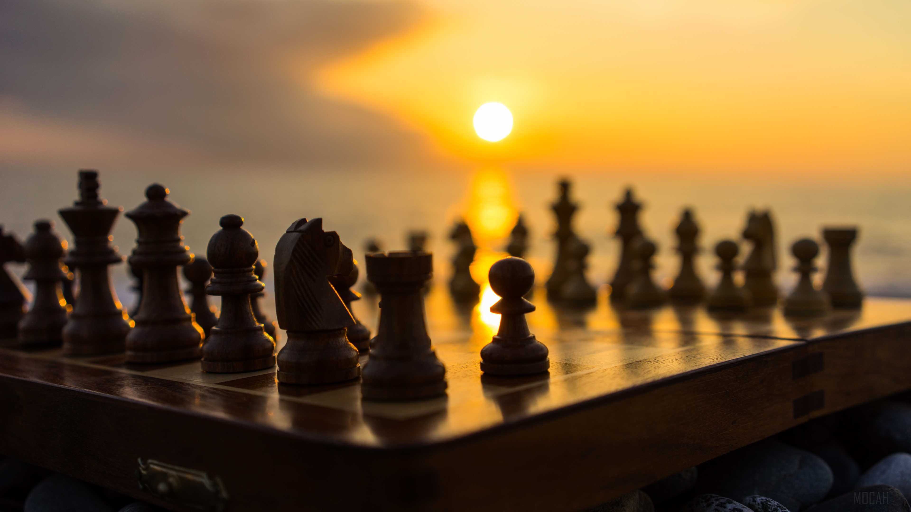 Chessboard with pieces at sunset HD Wallpaper