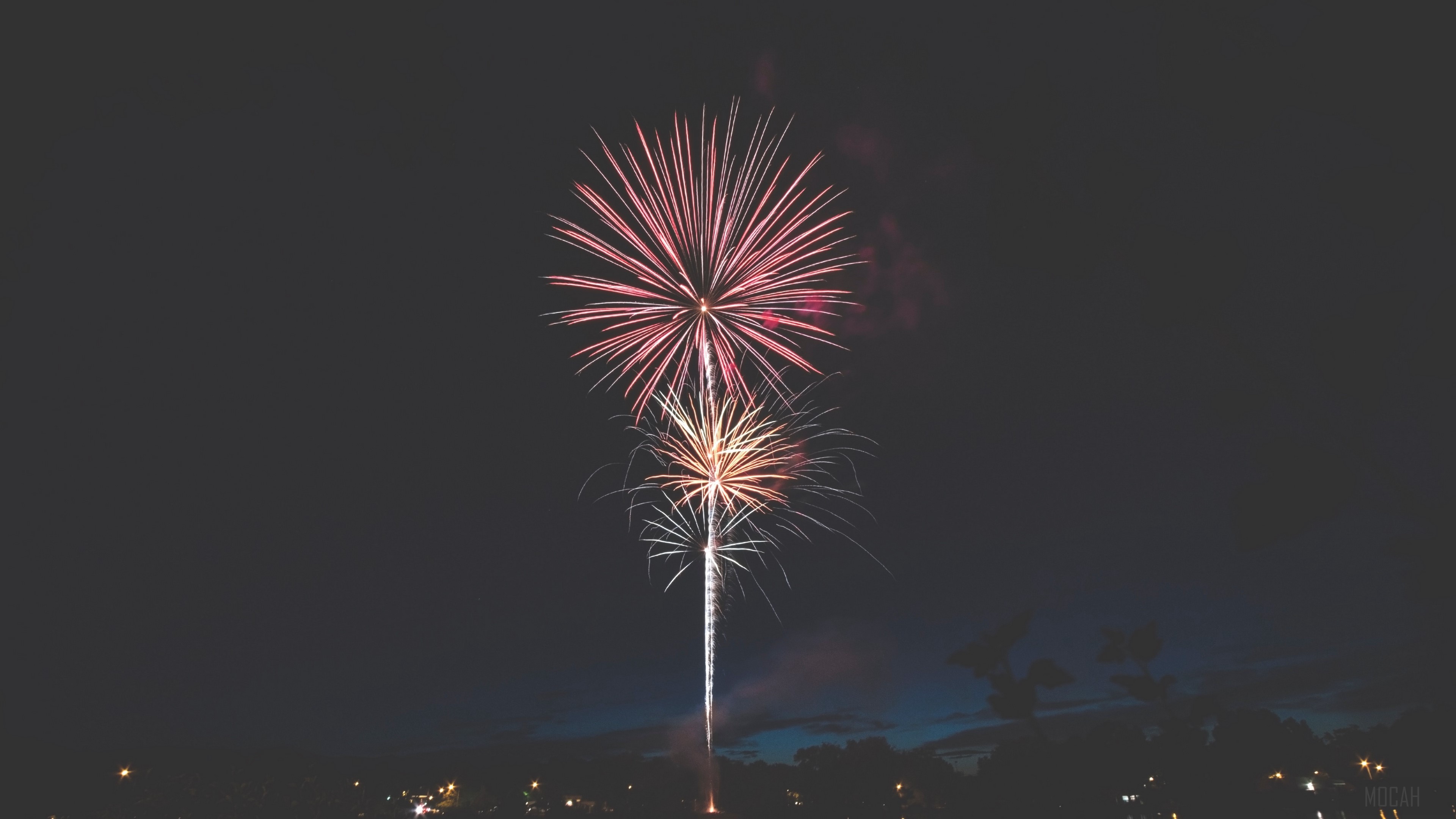 Fireworks display over a city at night HD Wallpaper