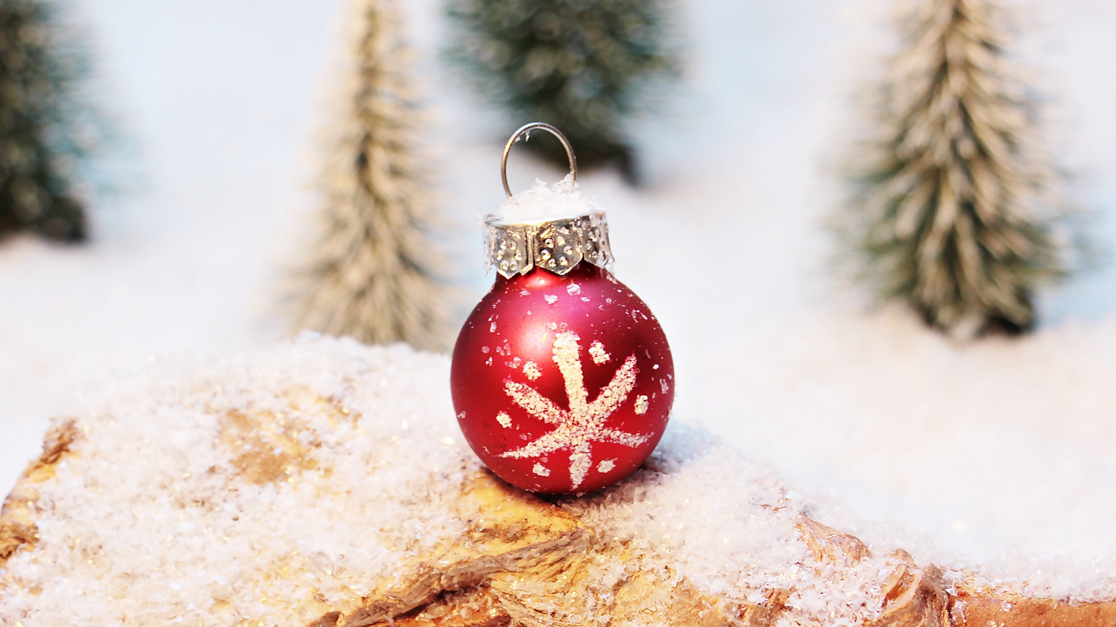 Red Christmas ornament with snowflake on snowy log HD Wallpaper