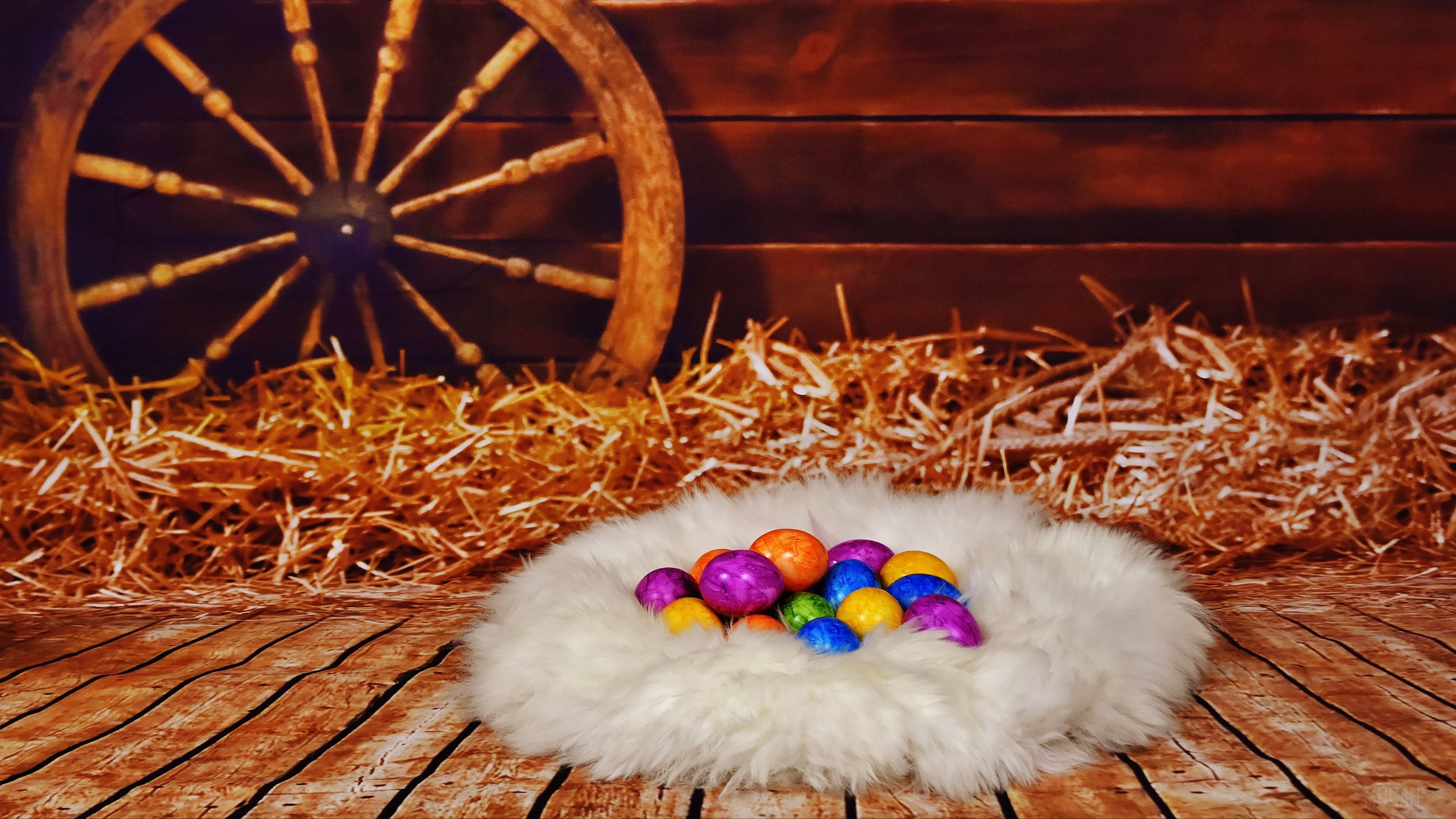 Easter eggs in a nest with hay and a wagon wheel HD Wallpaper
