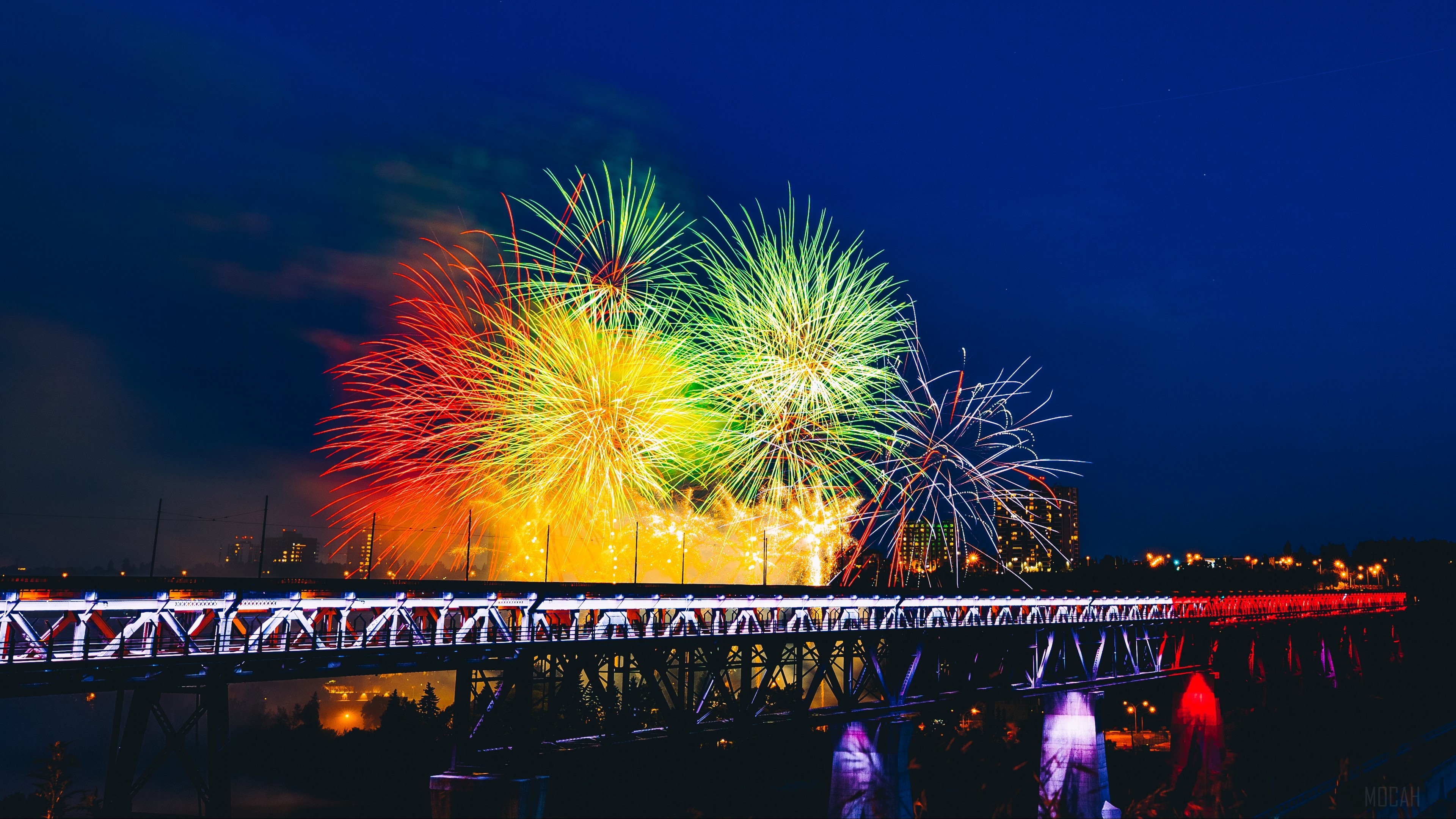 Colorful fireworks over a bridge at night HD Wallpaper