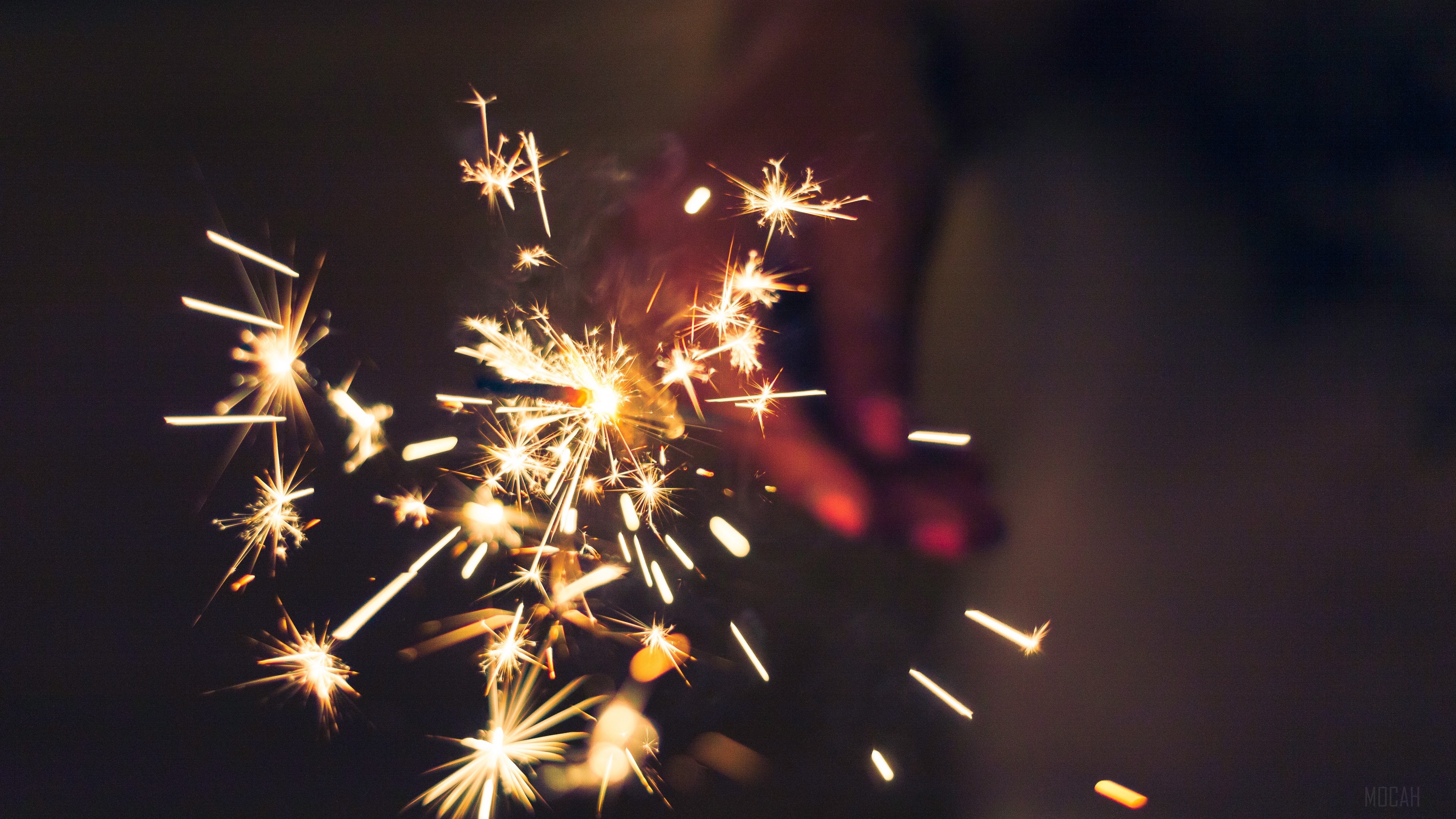 Sparklers held by a hand in the dark HD Wallpaper