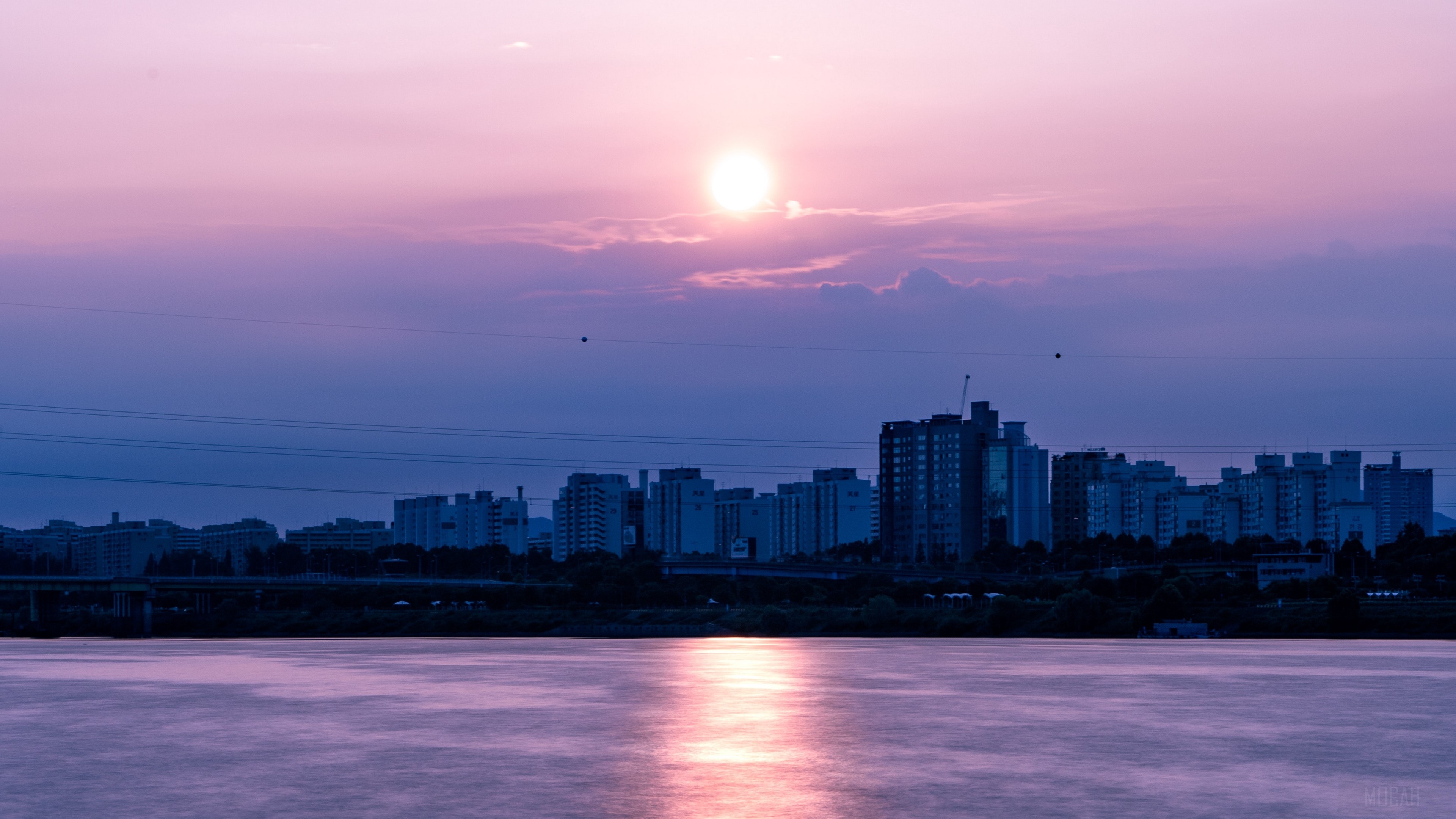 City skyline at sunset over a river HD Wallpaper