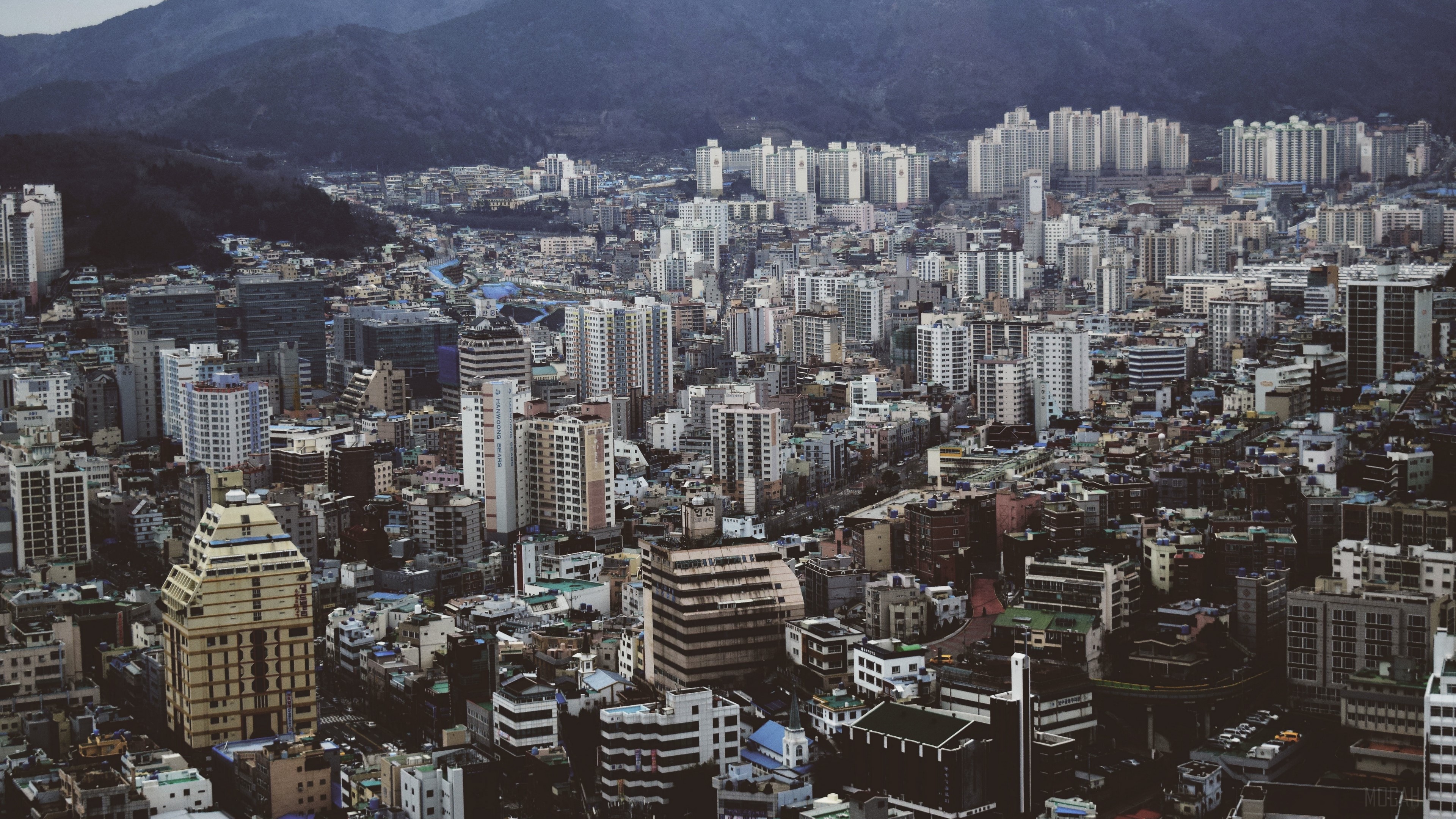 Cityscape with numerous buildings and mountains in the background, top view 4K HD Wallpaper