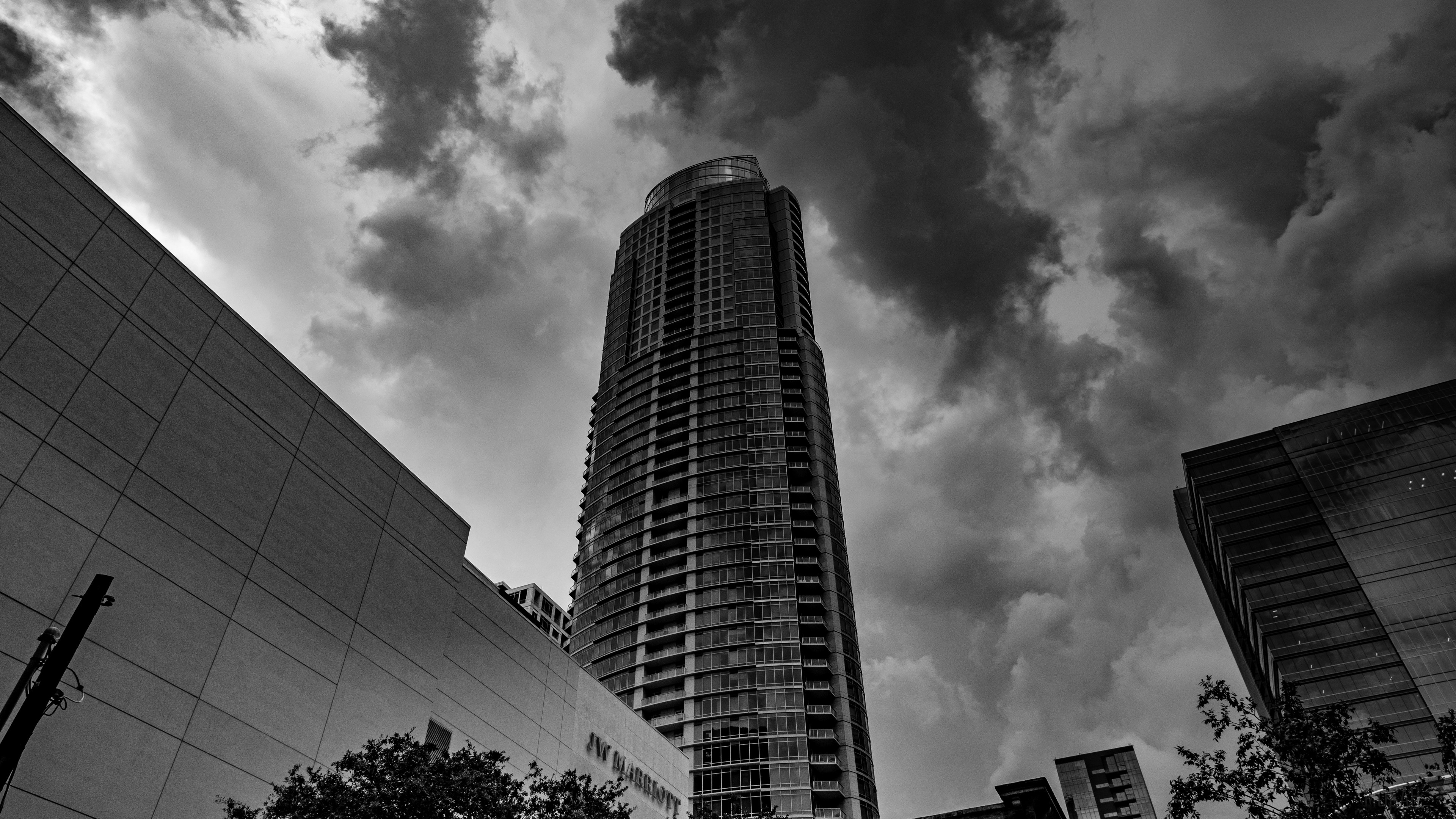 Skyscraper facade with clouds in black and white 4K HD Wallpaper