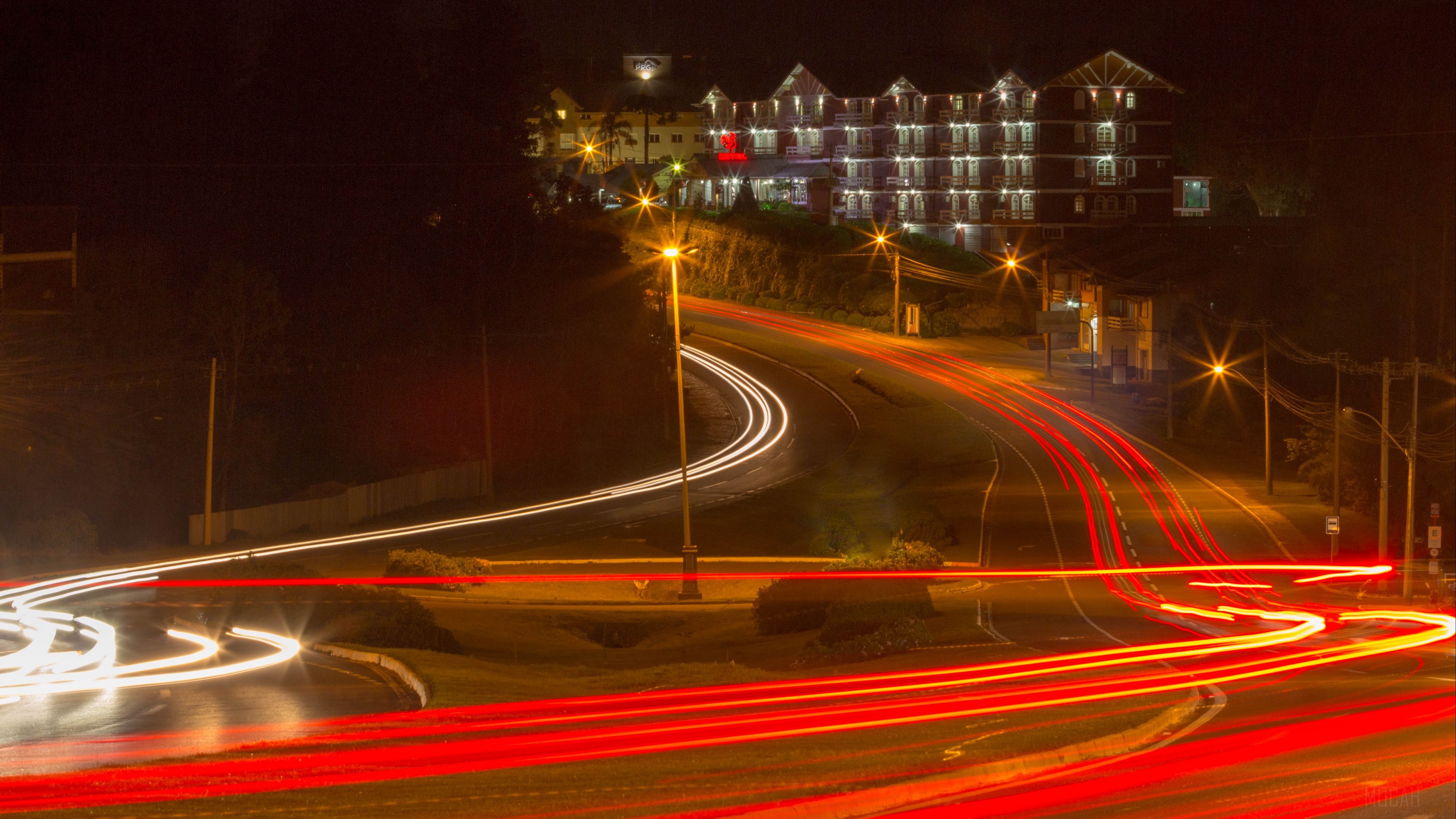Night road with light trails and a building HD Wallpaper