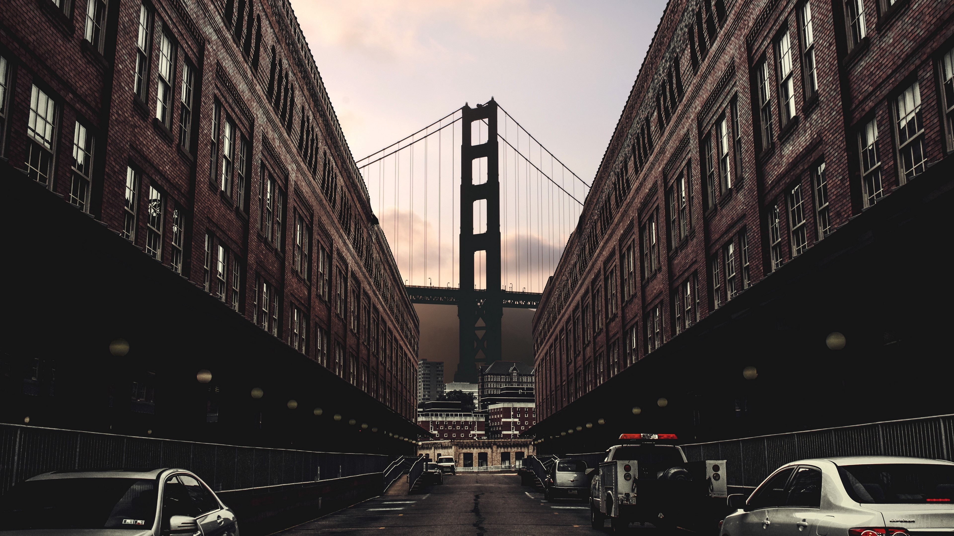 Golden Gate Bridge between brick buildings HD Wallpaper