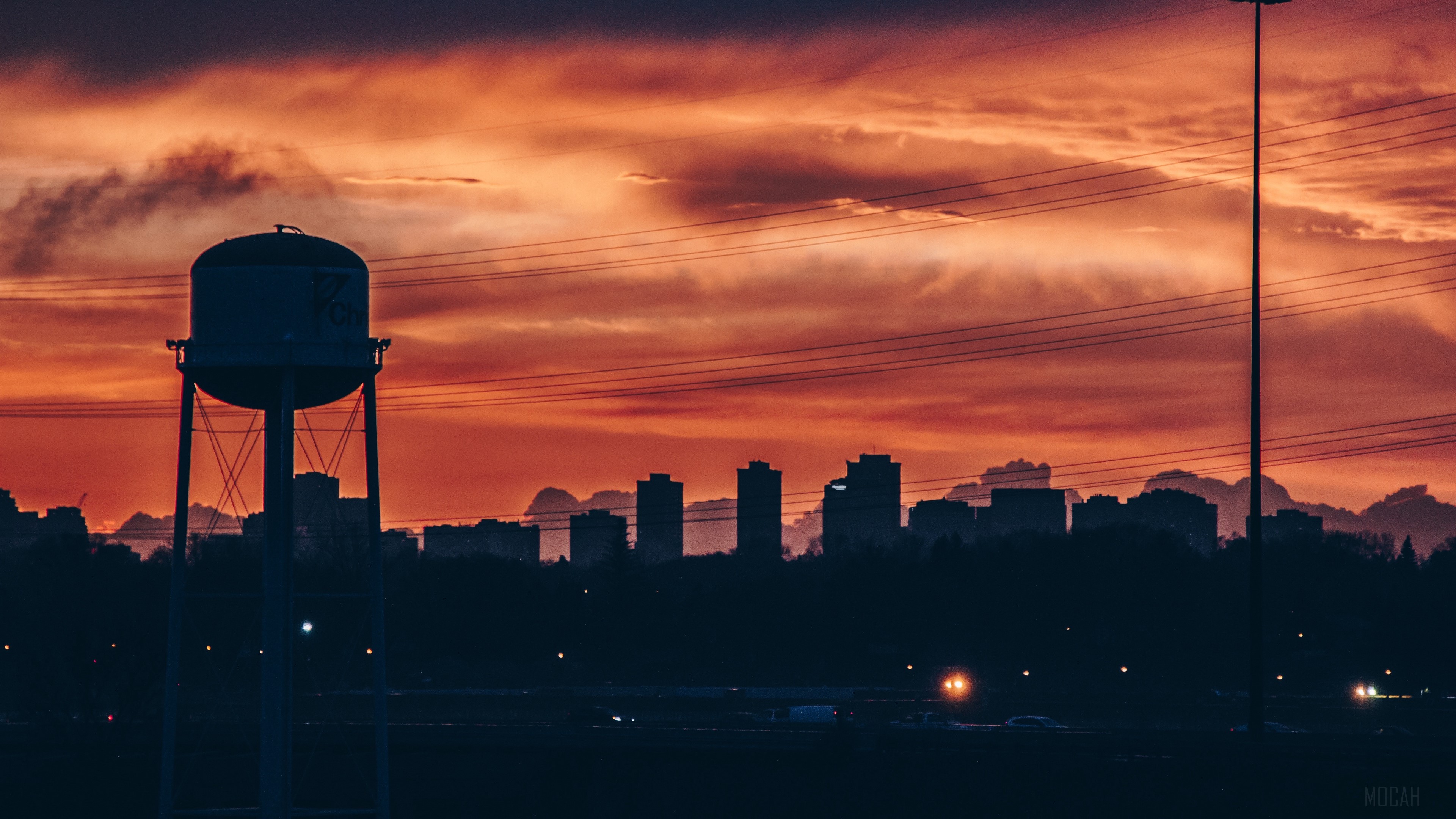 City skyline with water tower at sunset 4K HD Wallpaper