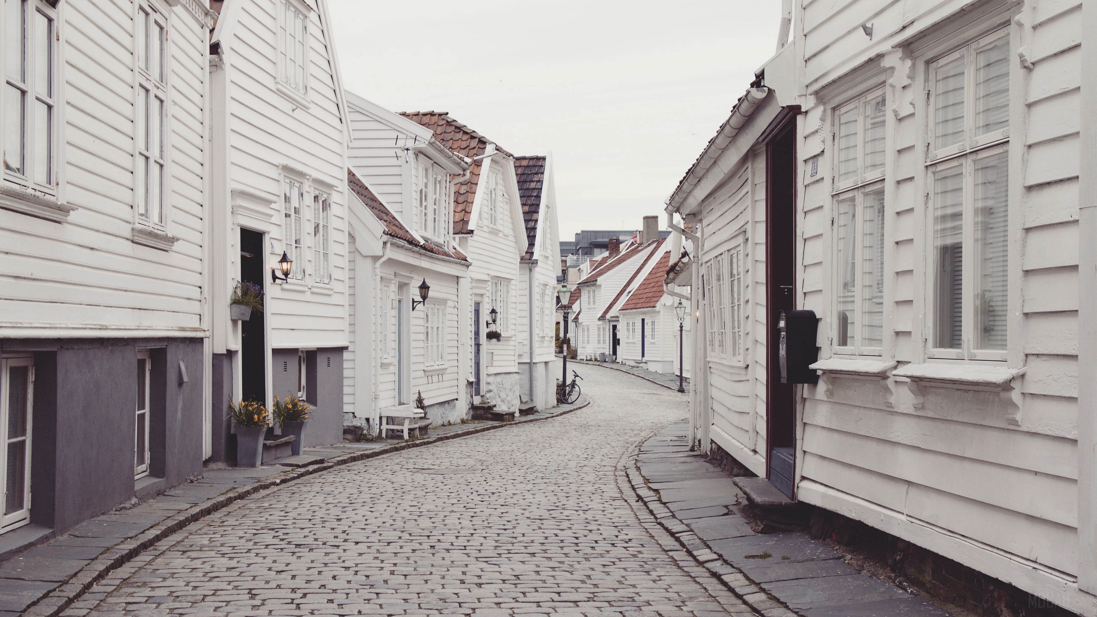 White wooden houses on a cobblestone street HD Wallpaper