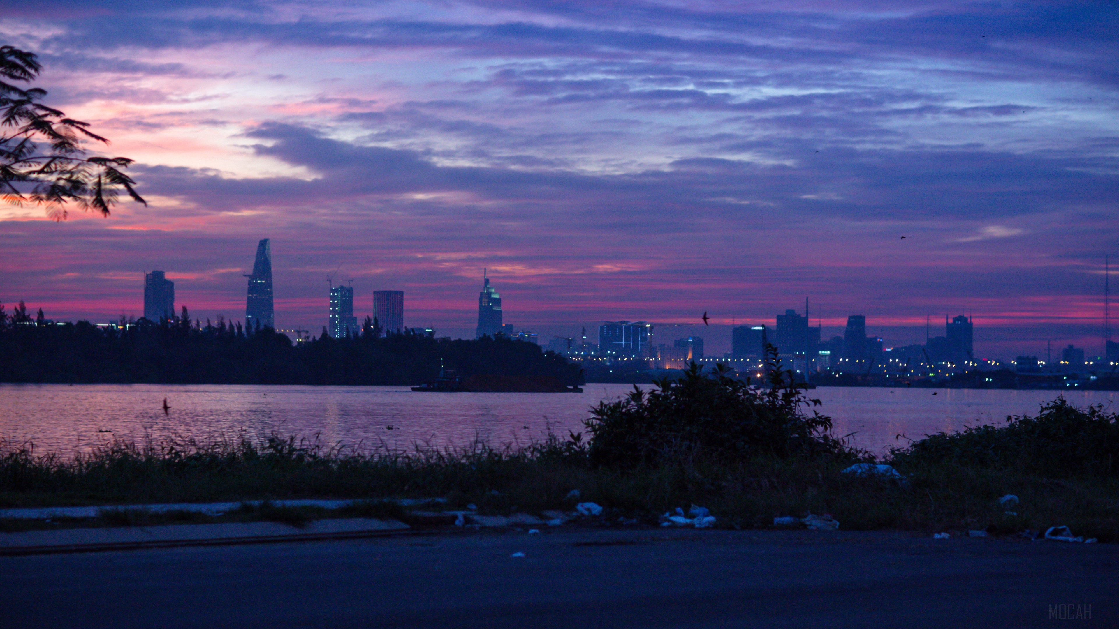 City skyline at dusk over a river HD Wallpaper