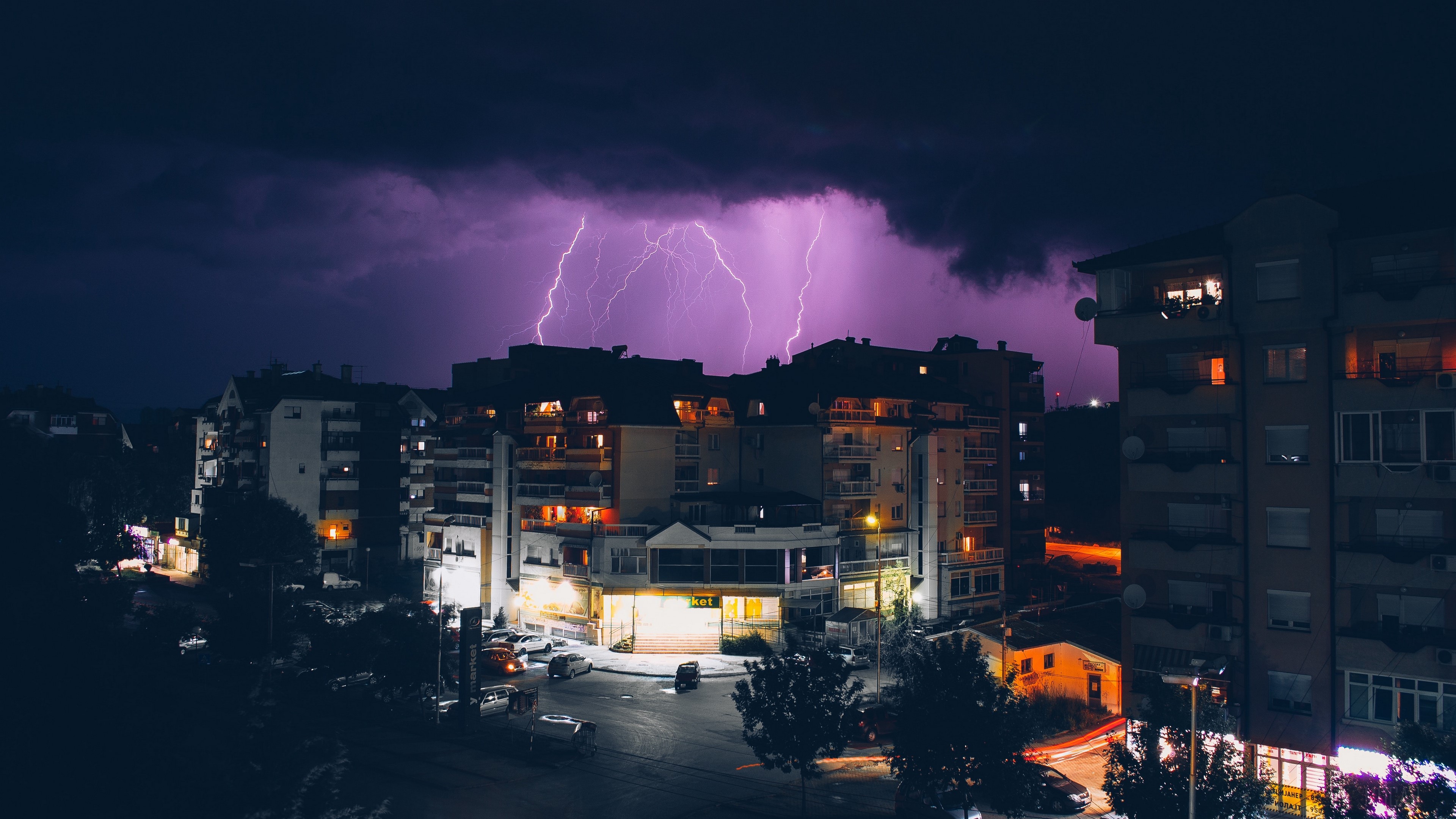 Lightning storm over city buildings at night HD Wallpaper