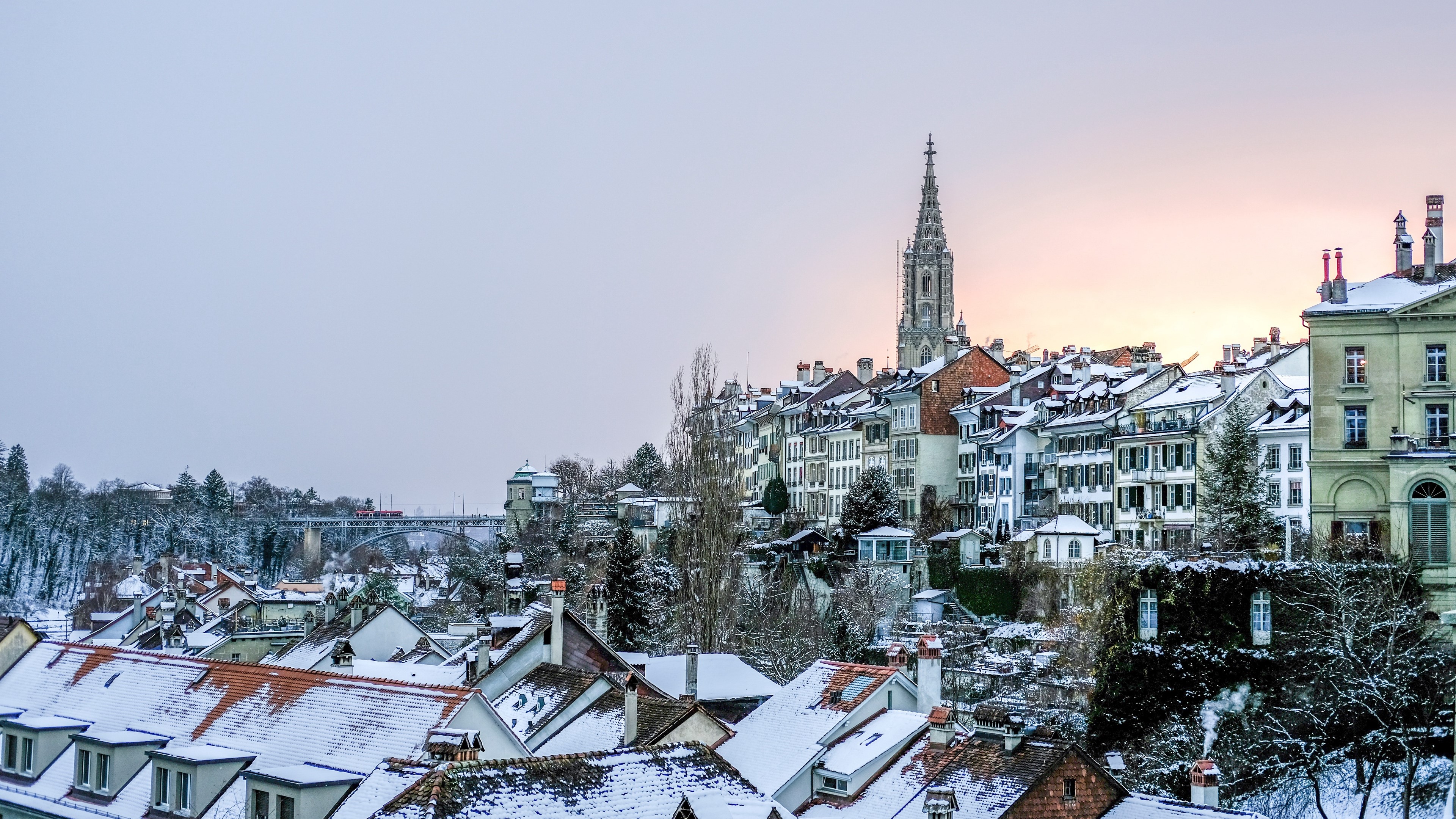 Bern cityscape with snow-covered roofs and a church tower HD Wallpaper
