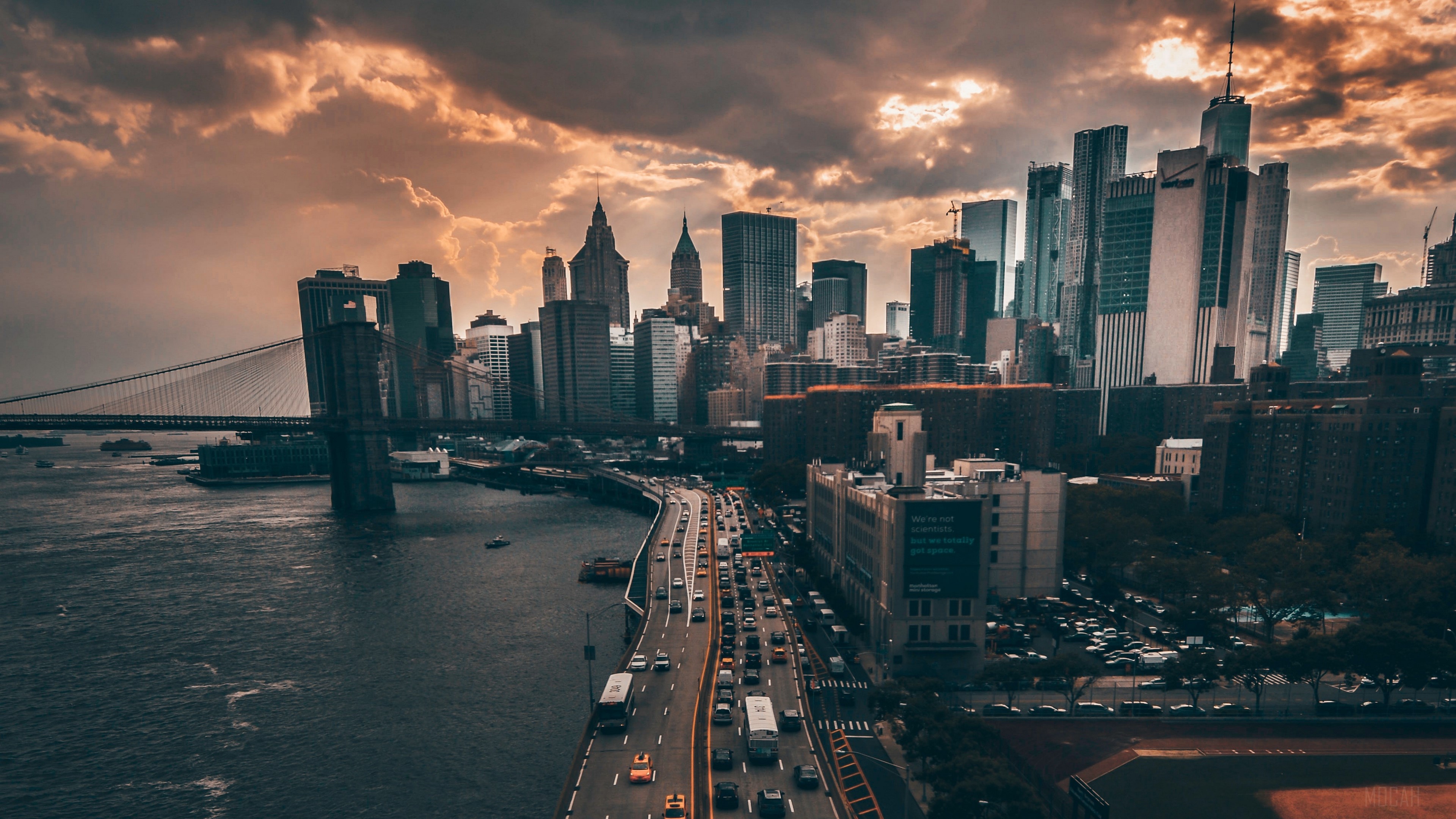 New York City skyline with Brooklyn Bridge and highway traffic at dusk HD Wallpaper