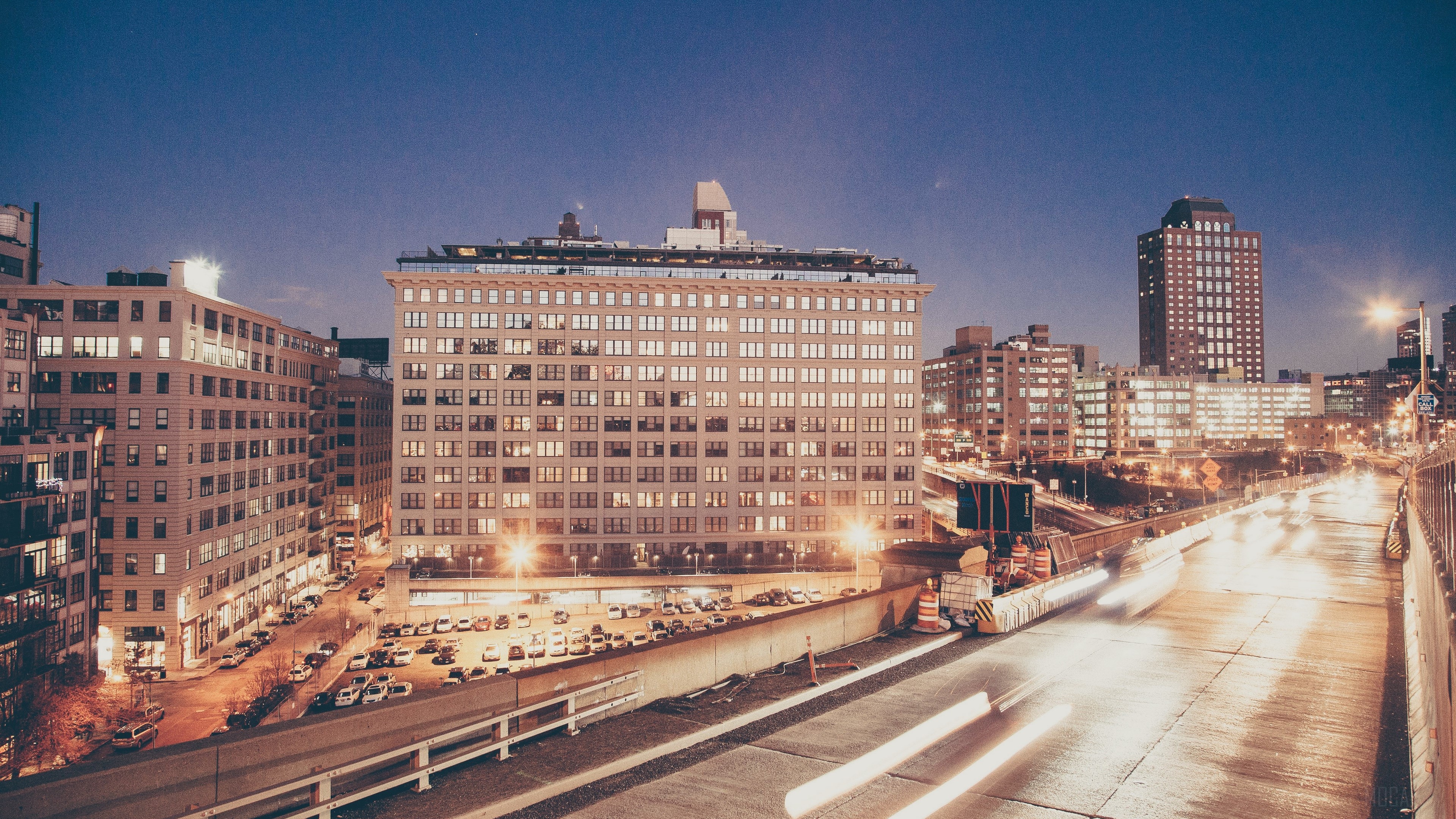 City skyline at night with highway traffic HD Wallpaper