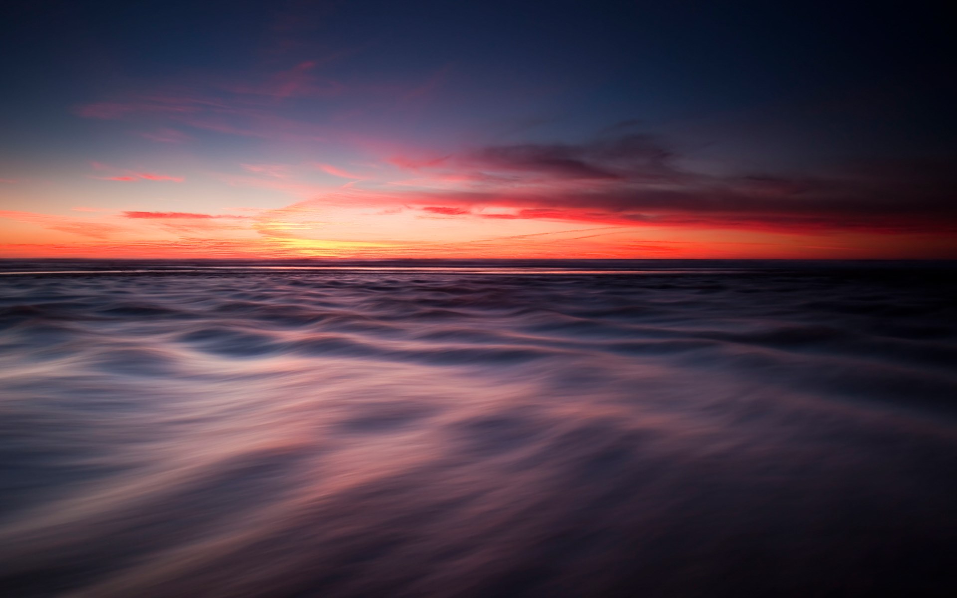 Sunset over ocean with blurred waves HD Wallpaper
