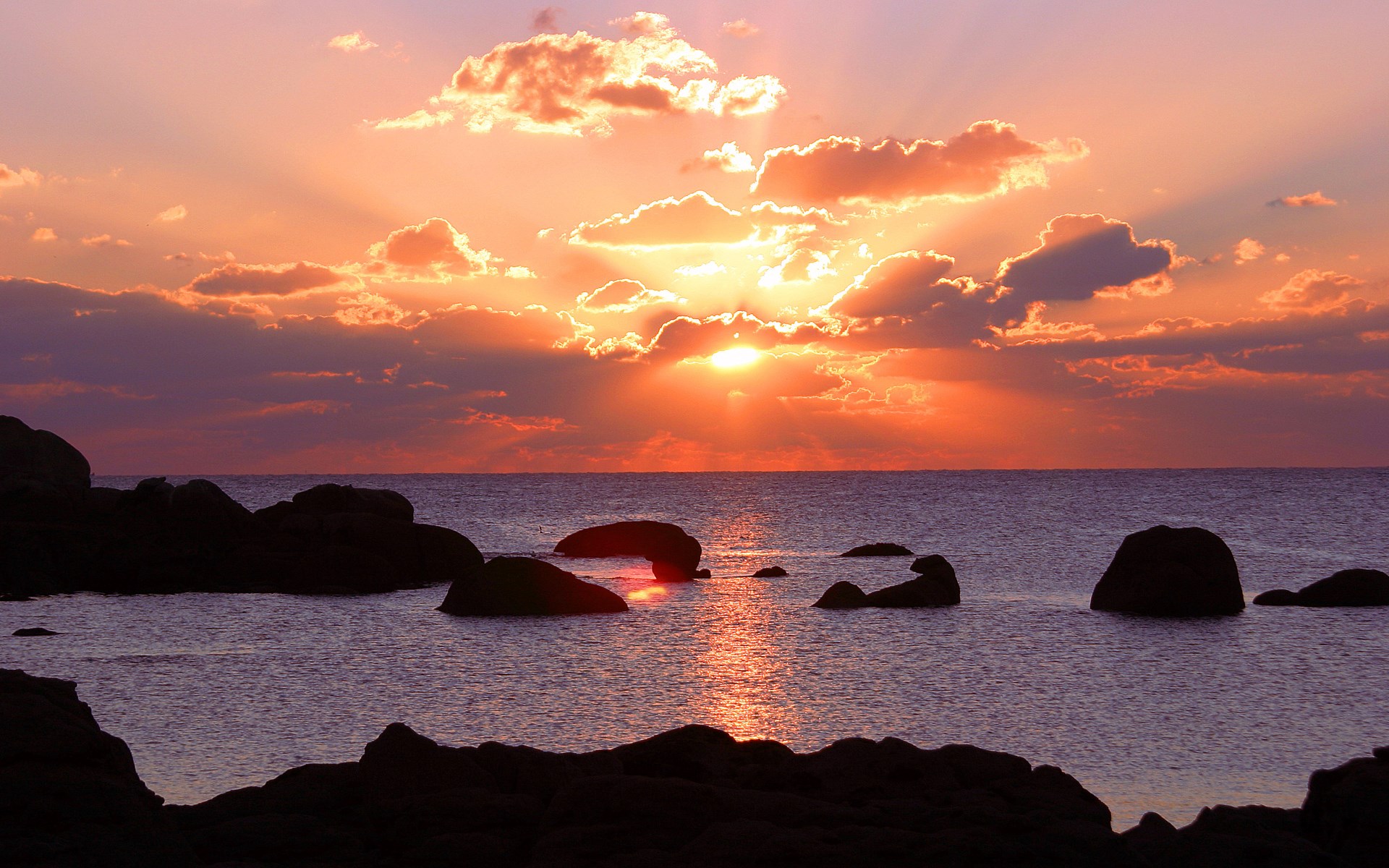 Sunset over the ocean with rocks HD Wallpaper