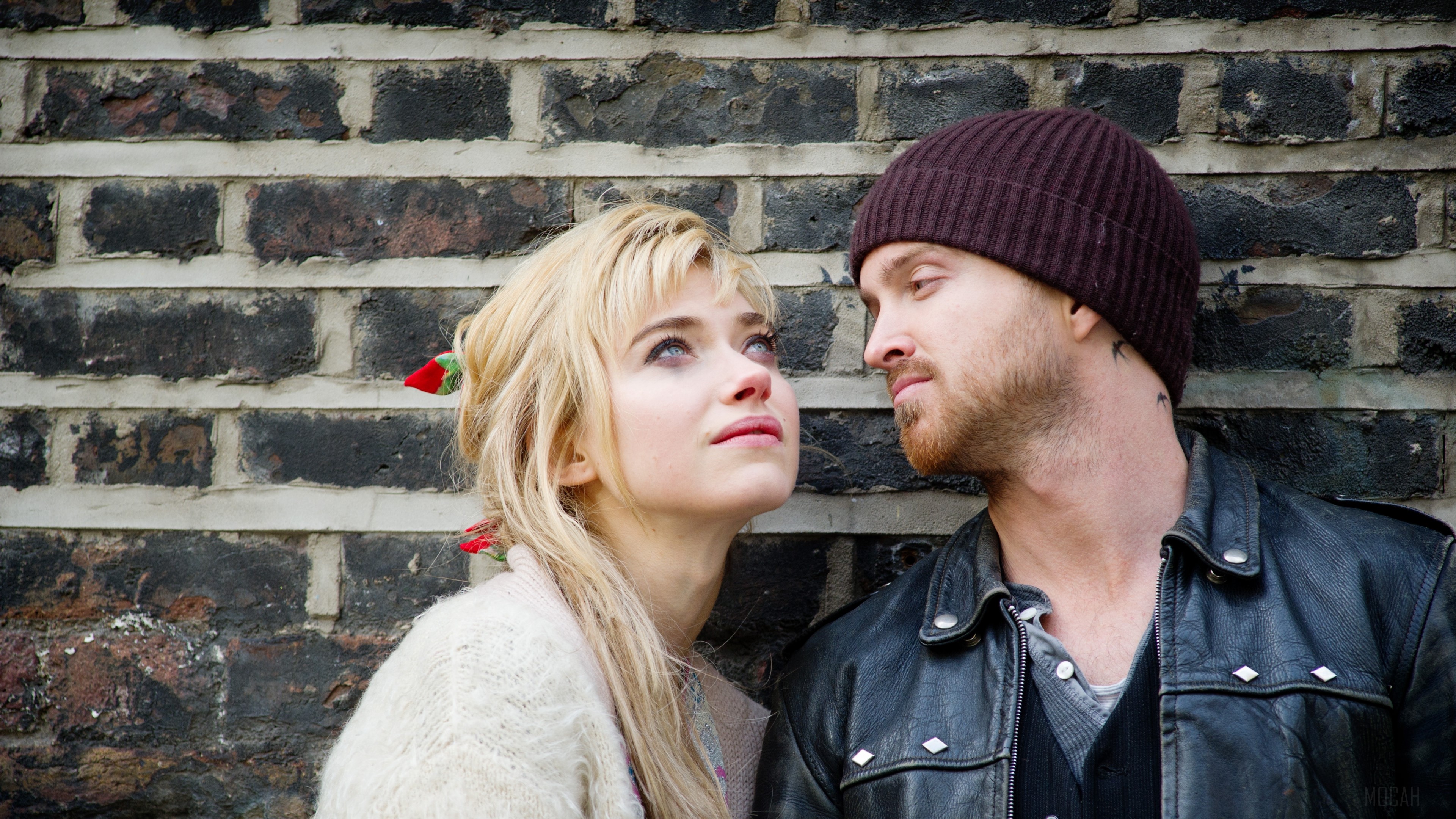 Aaron Paul and woman leaning against brick wall HD Wallpaper