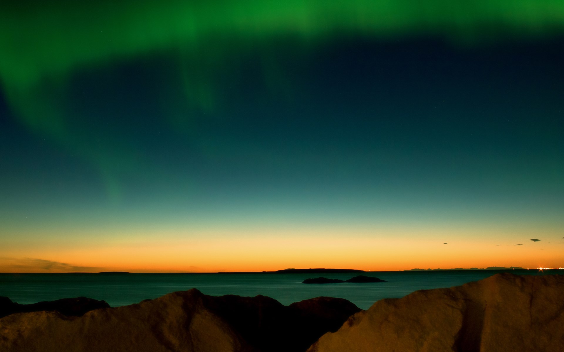 Aurora Borealis over ocean and mountains at twilight HD Wallpaper