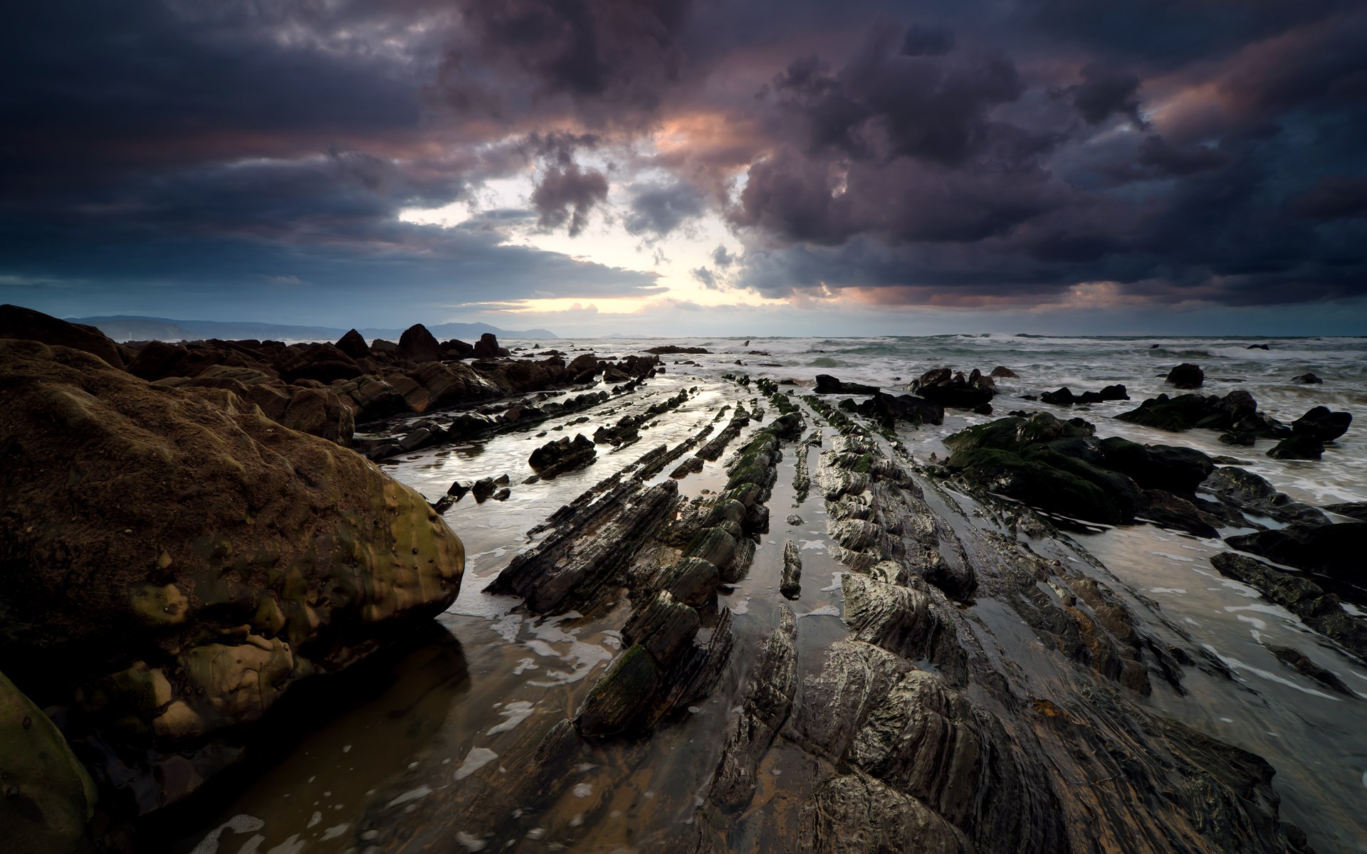 Rocky coastline with dramatic clouds at sunset HD Wallpaper
