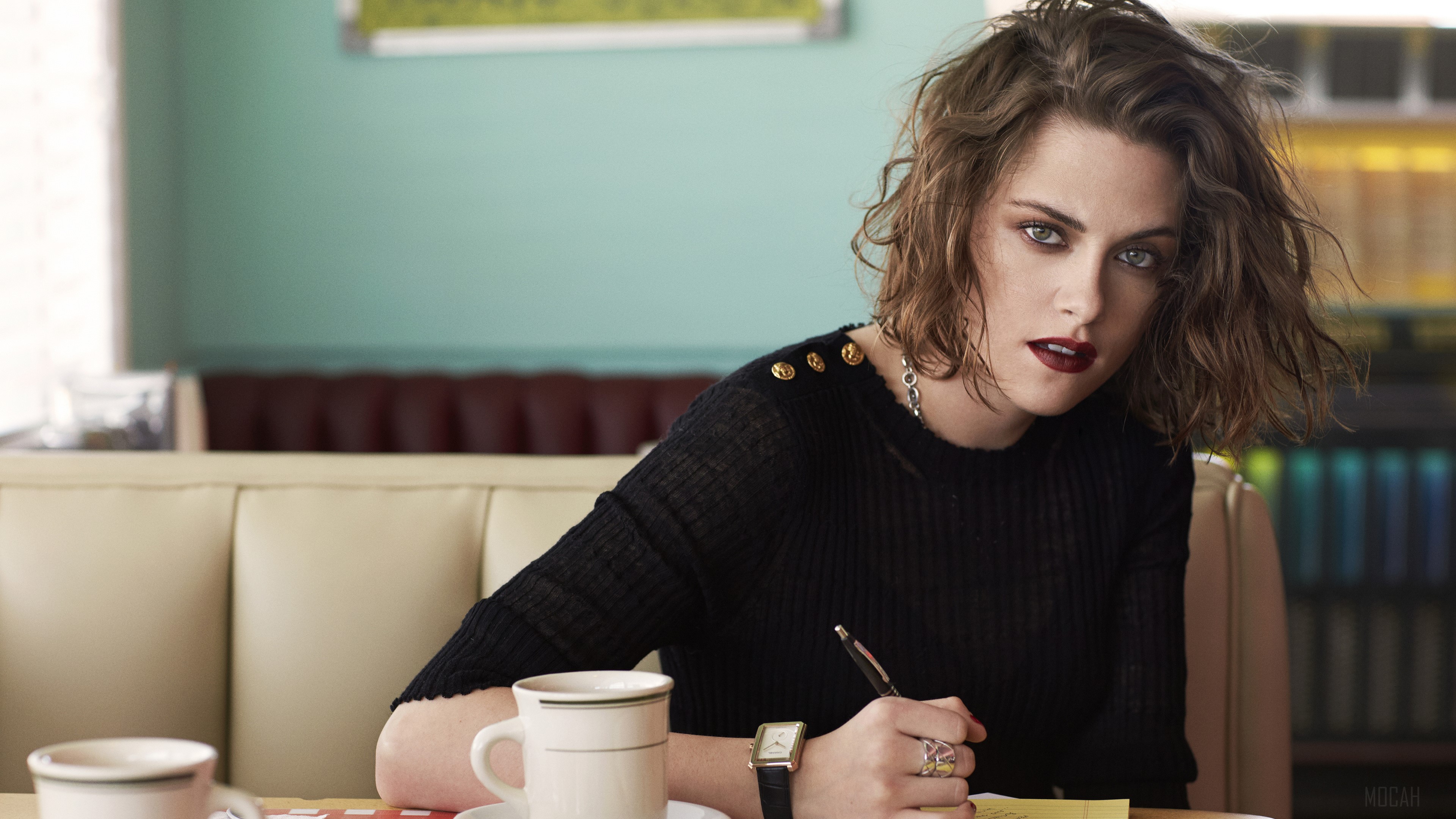 Kristen Stewart in a black top writing at a diner HD Wallpaper