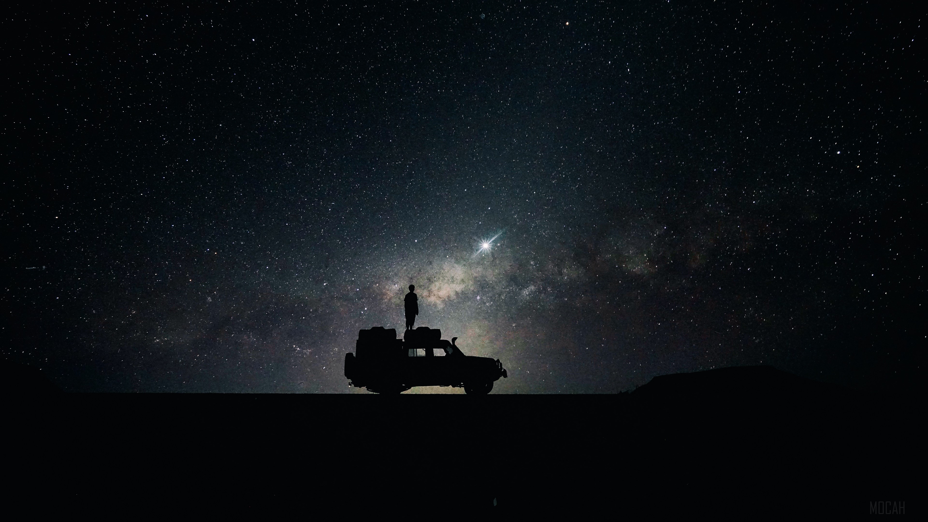 Silhouette of a person on a car under the stars HD Wallpaper