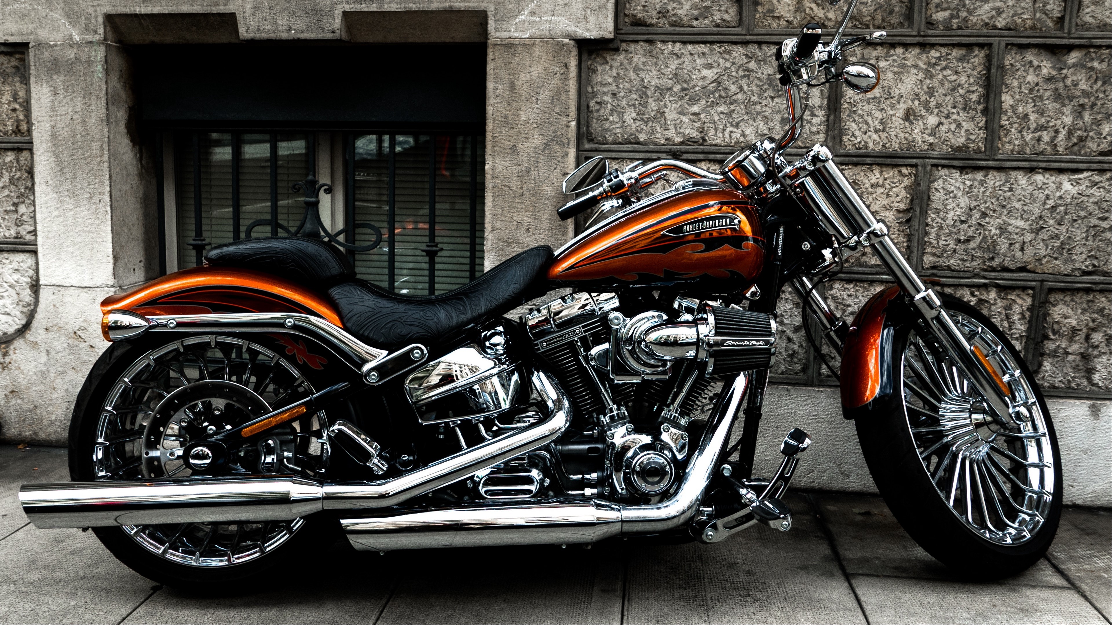 Harley Davidson motorcycle parked by a stone wall HD Wallpaper