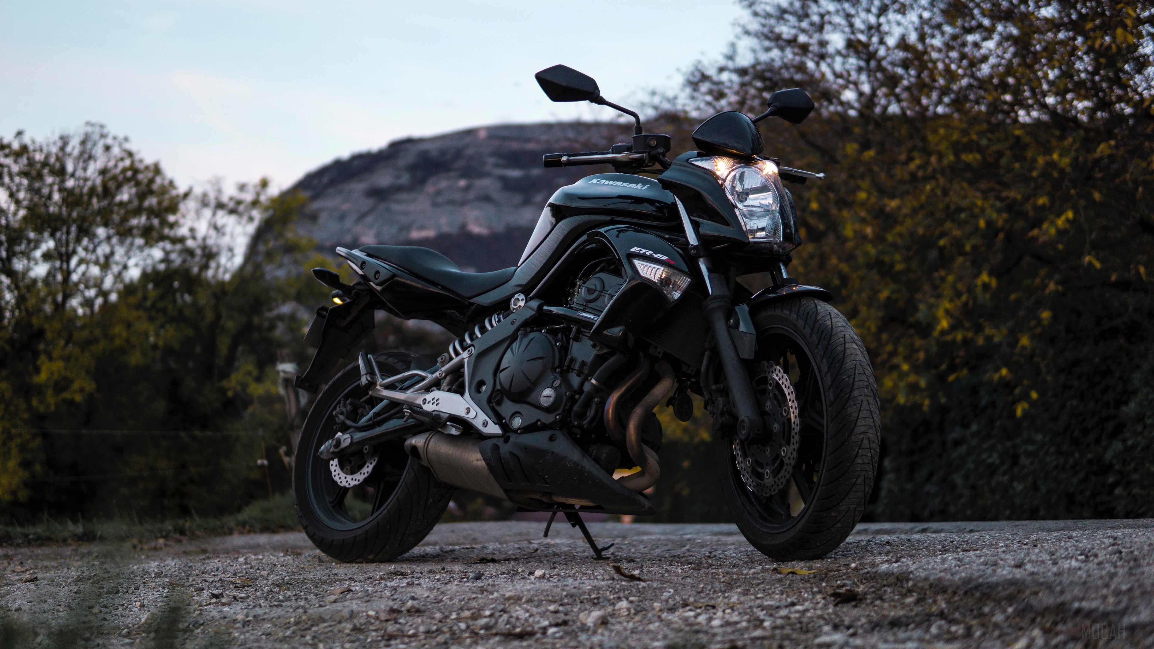 Black Kawasaki ER-6n motorcycle on a gravel road HD Wallpaper