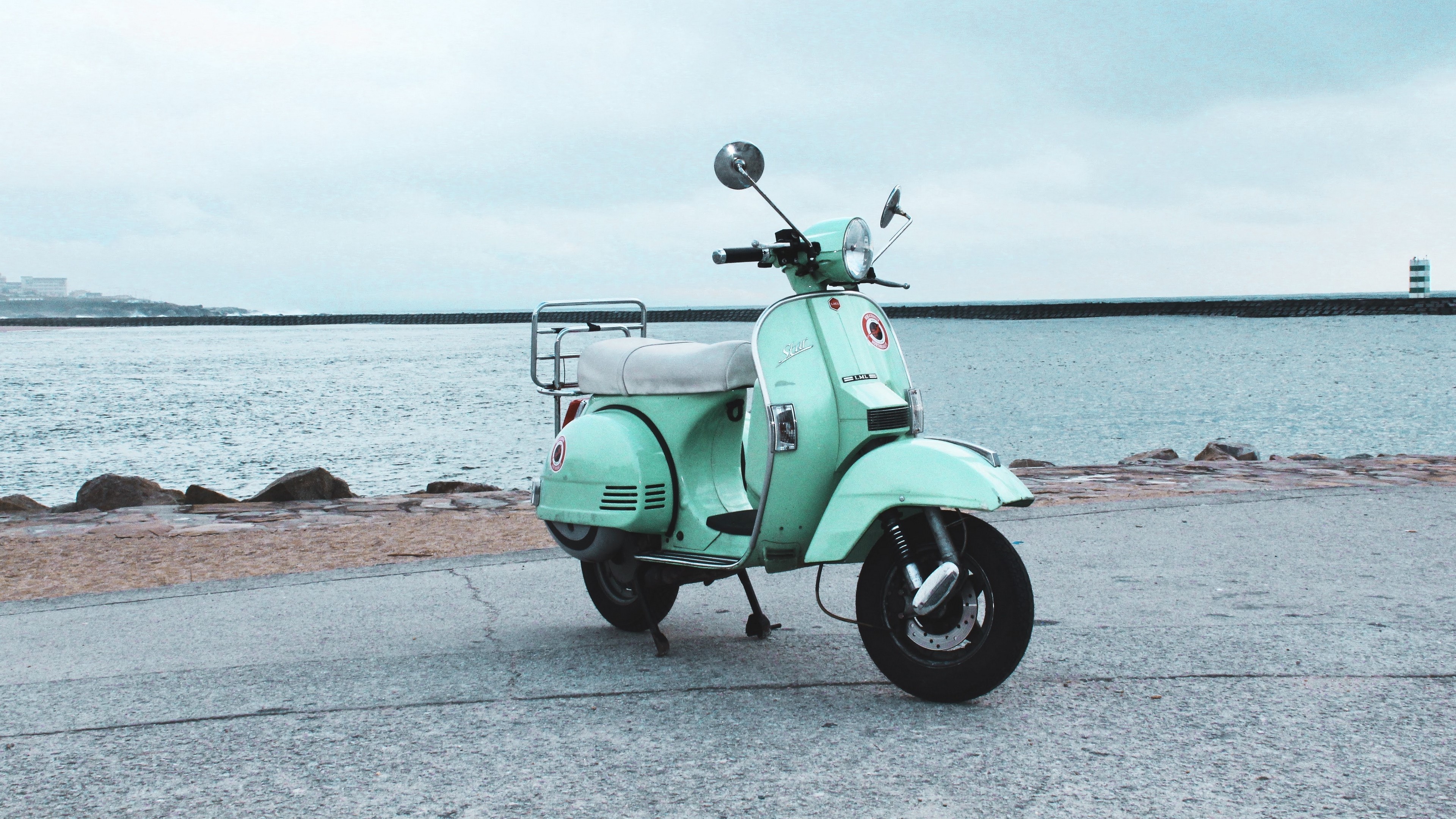 Mint green scooter parked by the sea HD Wallpaper