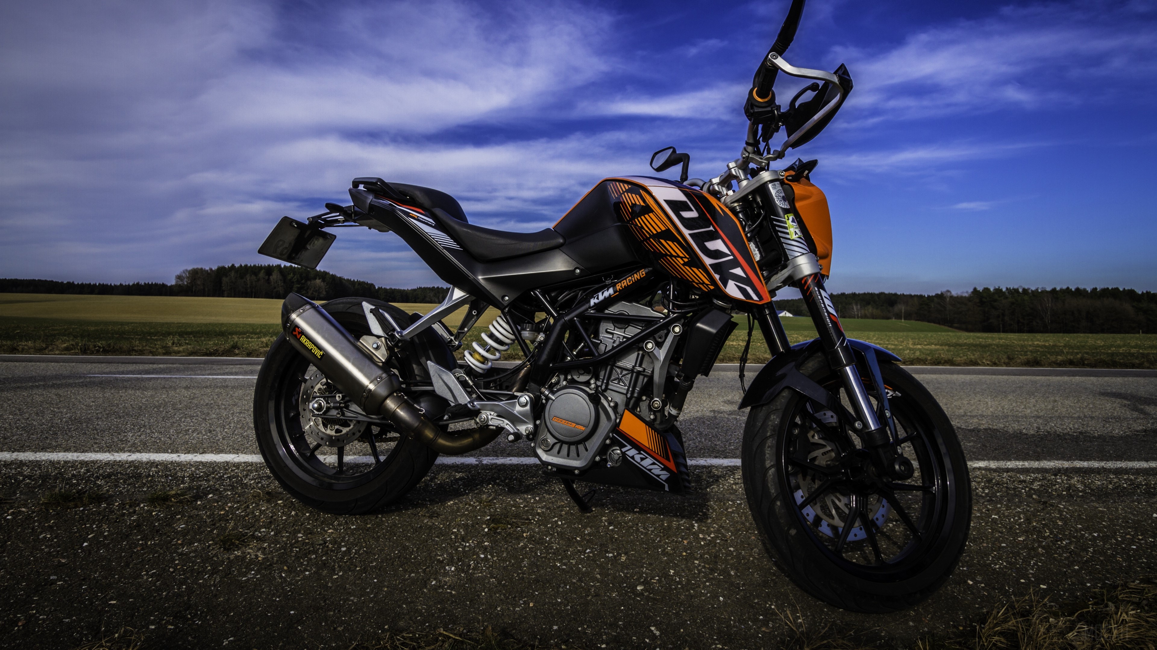 KTM motorcycle on a road with fields and sky HD Wallpaper