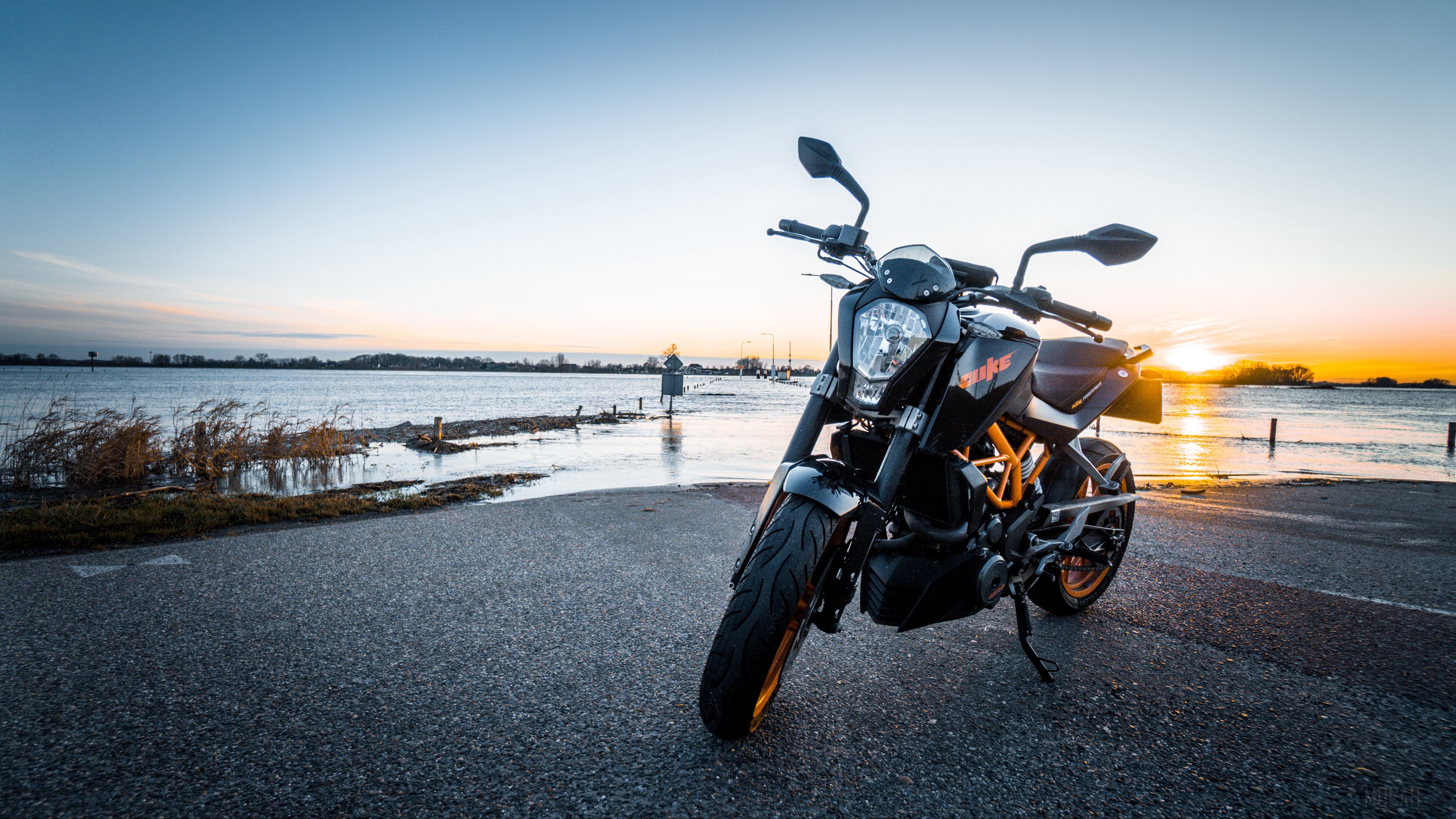 KTM motorcycle parked by flooded road at sunset HD Wallpaper