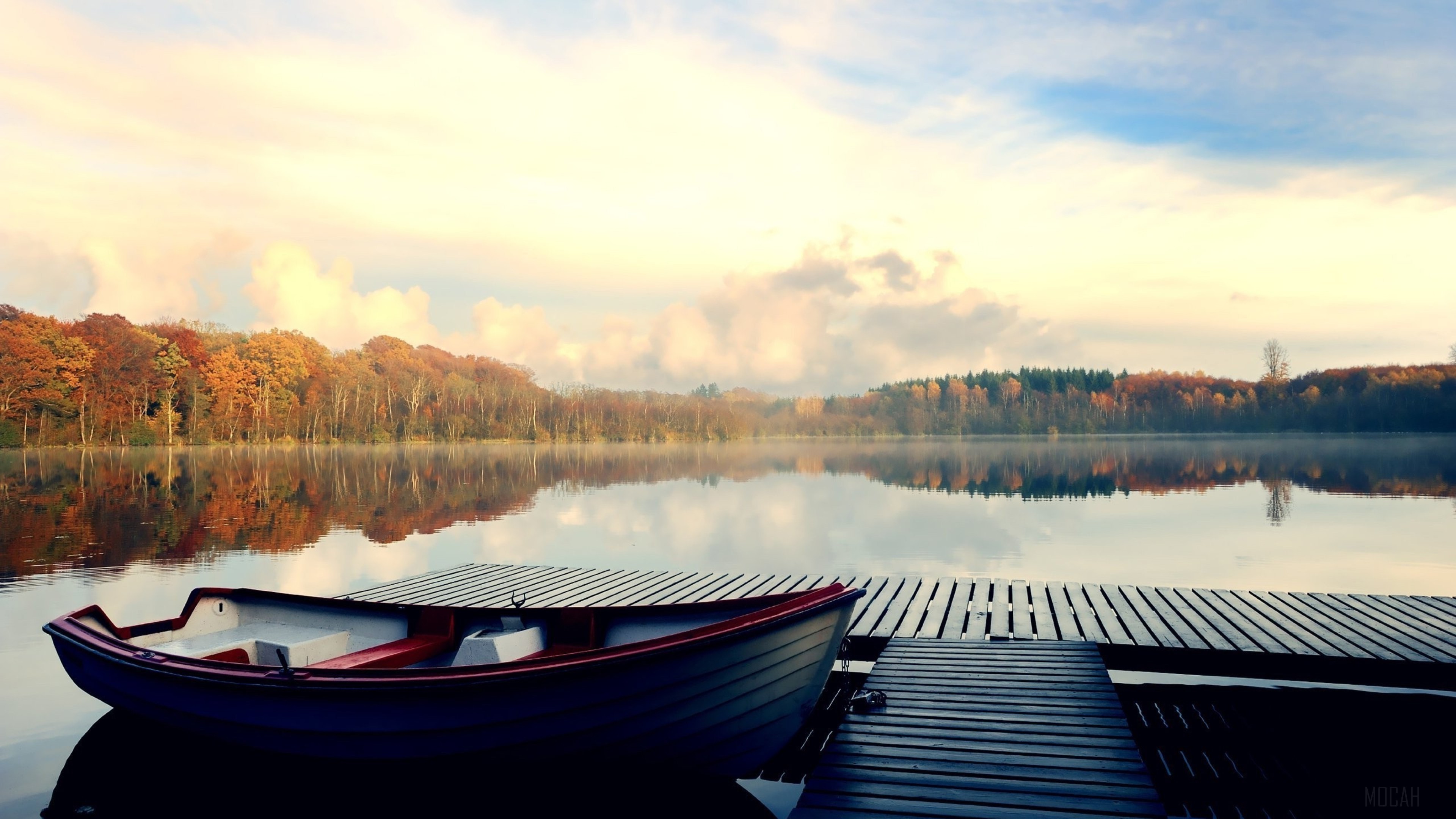 Boat on a dock by a lake with autumn trees HD Wallpaper