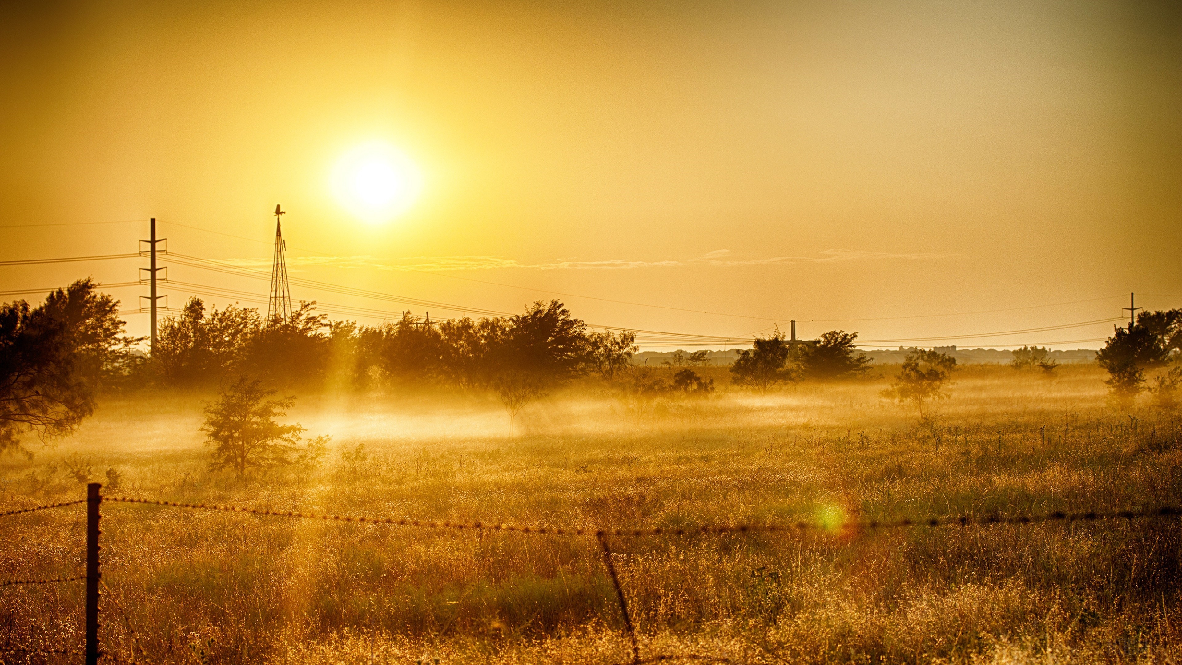 Sunrise over a misty field with a windmill HD Wallpaper