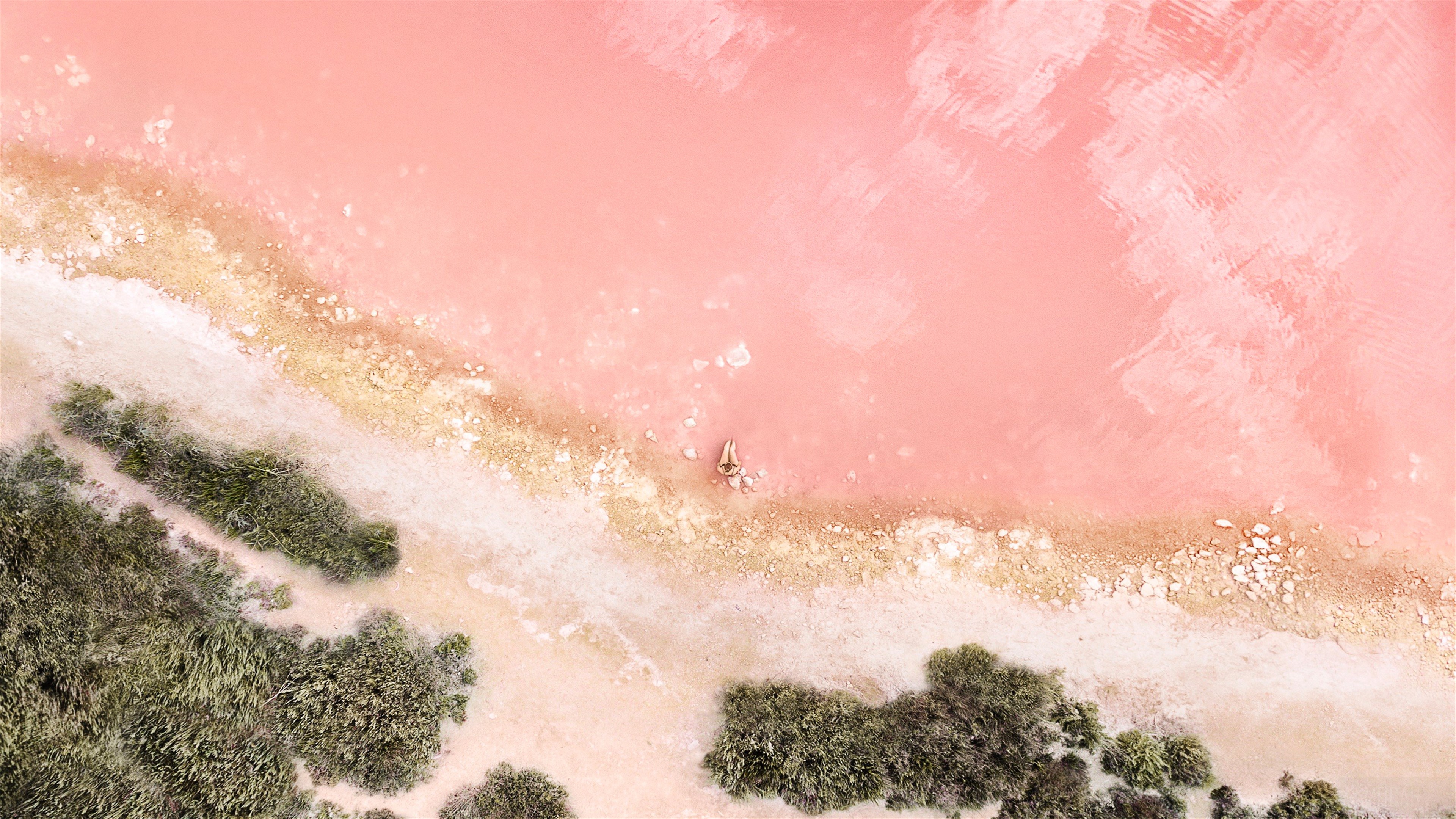 Person relaxing in pink salt lake HD Wallpaper
