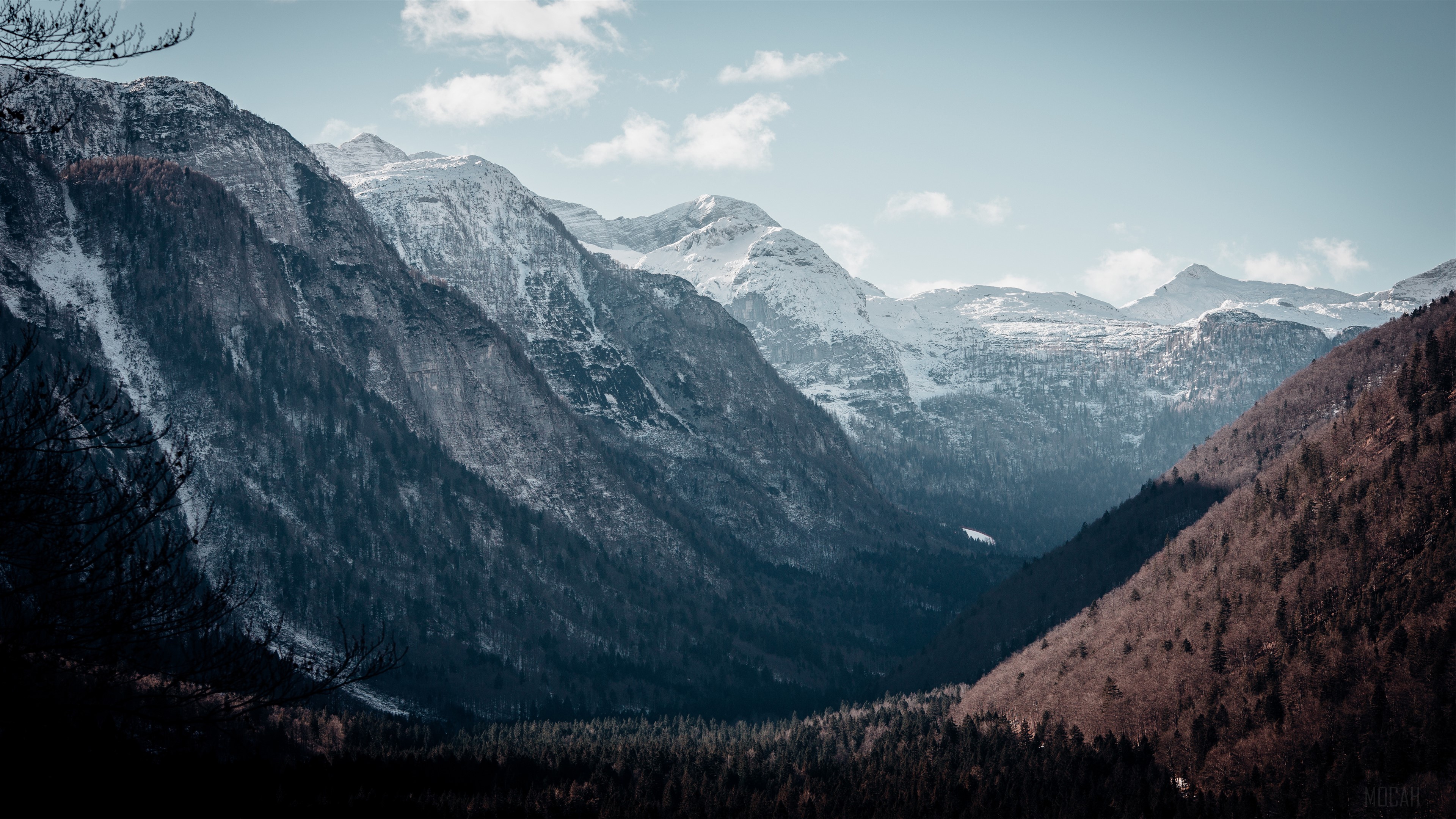 Snow-capped mountain peaks in a valley HD Wallpaper
