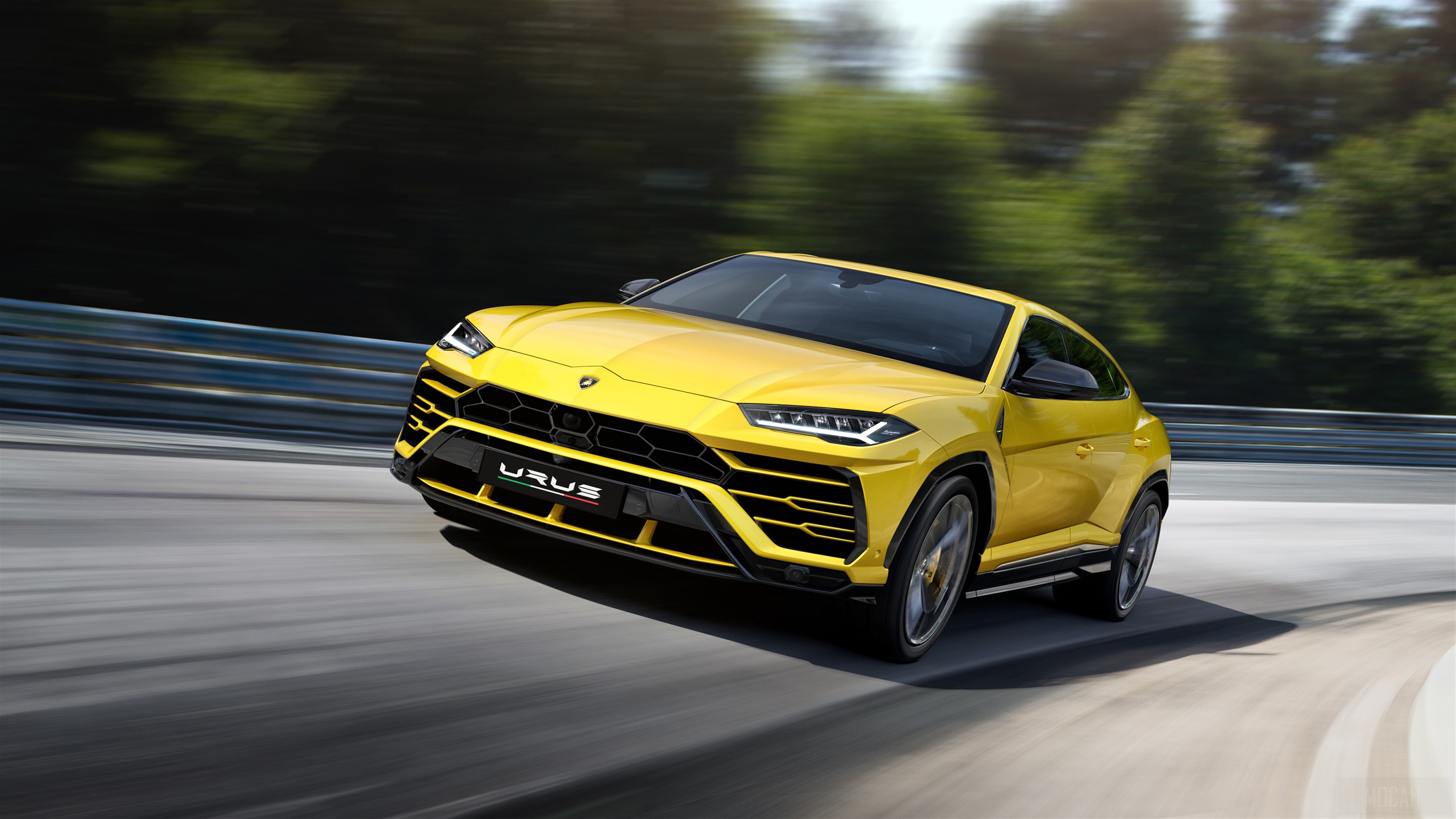 Yellow Lamborghini Urus driving on a track HD Wallpaper