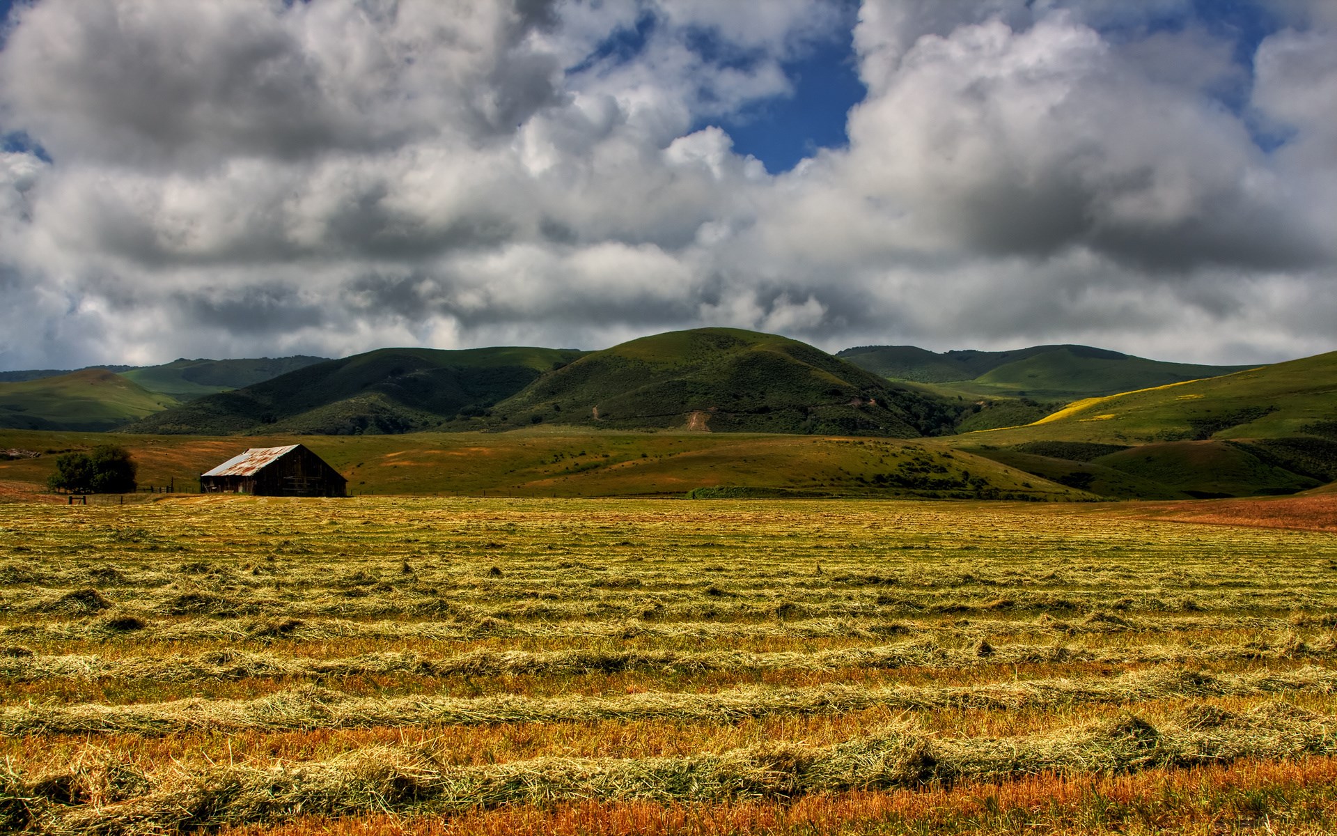 Barn in a field with rolling hills and clouds HD Wallpaper