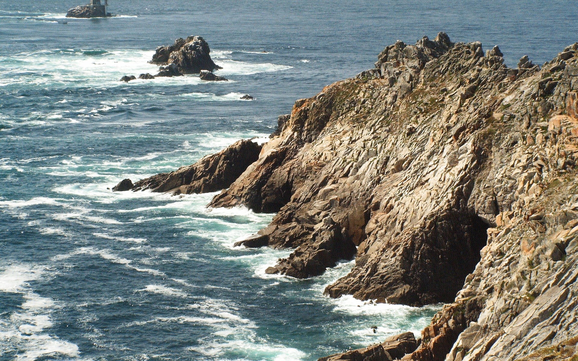 Rocky coastline with waves crashing against rocks HD Wallpaper