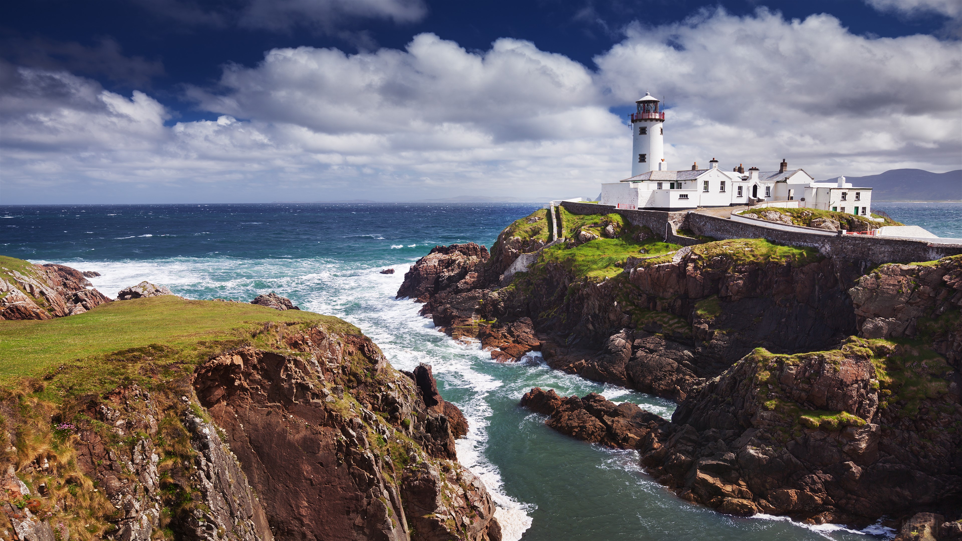 White Lighthouse on Rocky Coastline Overlooking Ocean HD Wallpaper