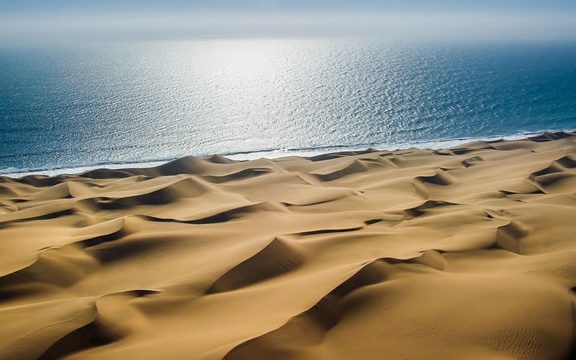 Sand dunes meet the ocean HD Wallpaper