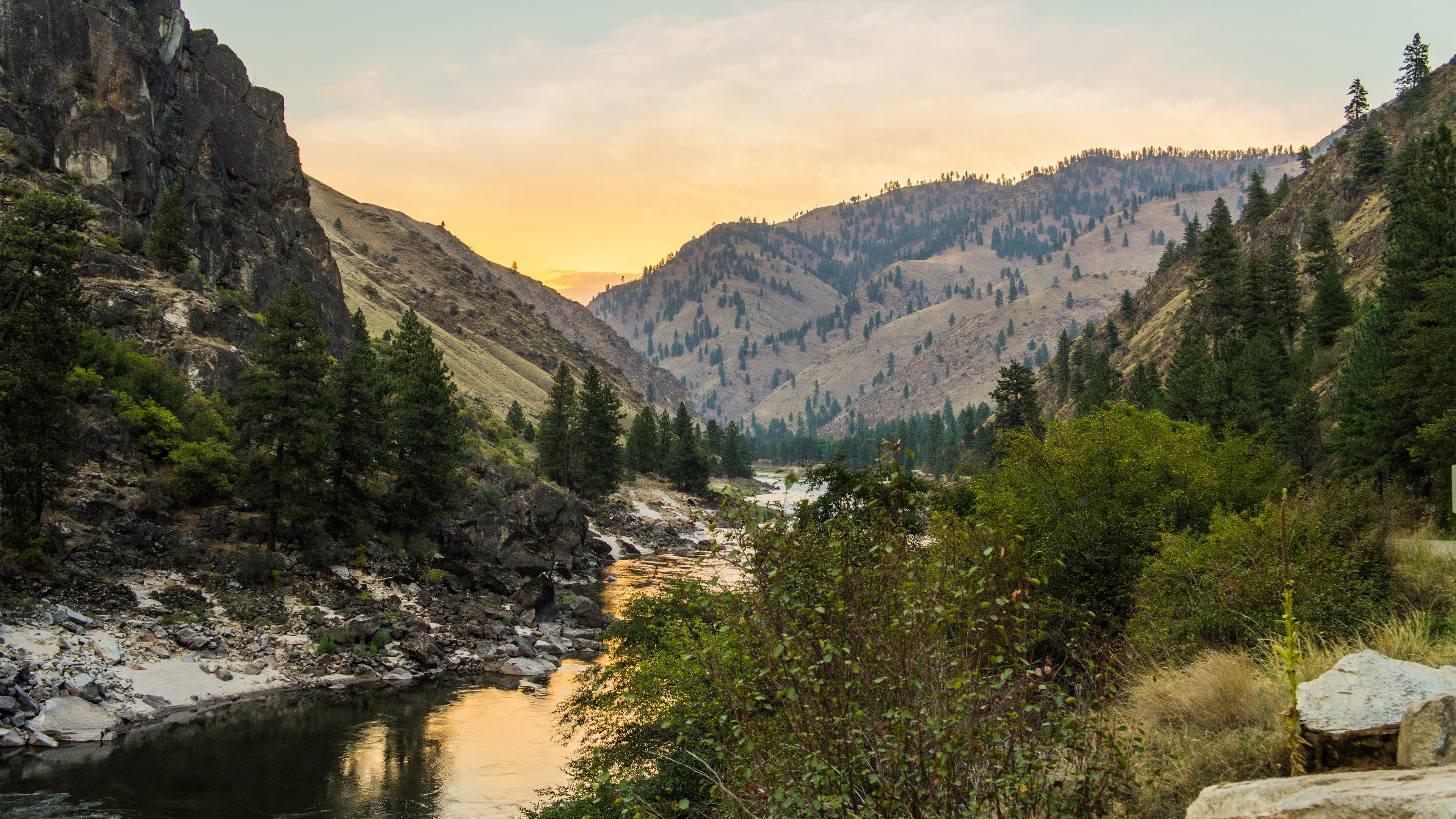 River flowing through a mountain valley at sunset HD Wallpaper