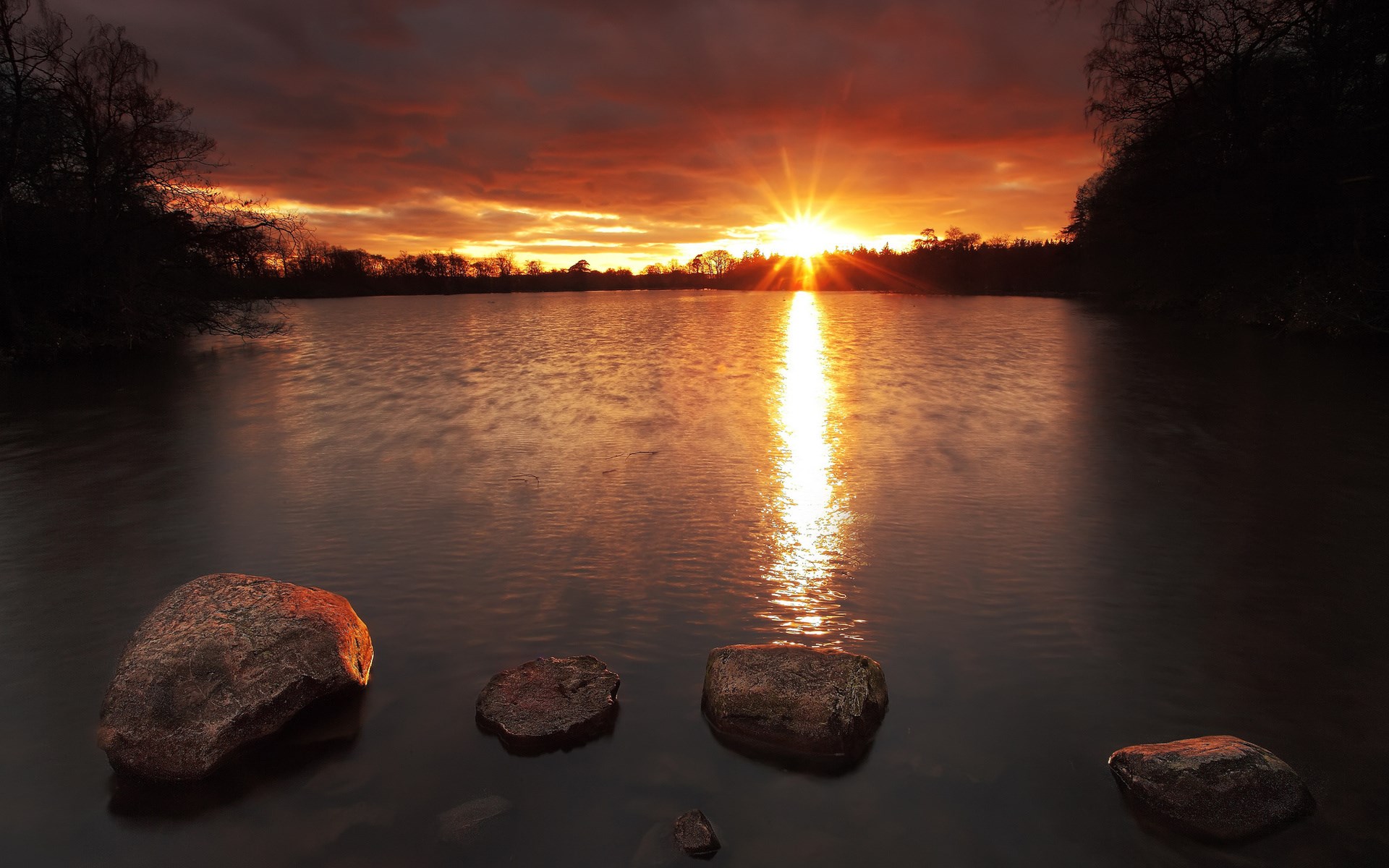Sunset over a lake with rocks in the foreground HD Wallpaper