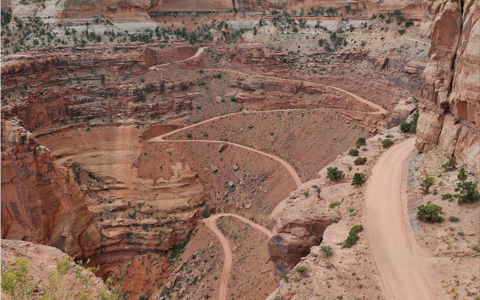 Winding dirt road through a desert canyon HD Wallpaper