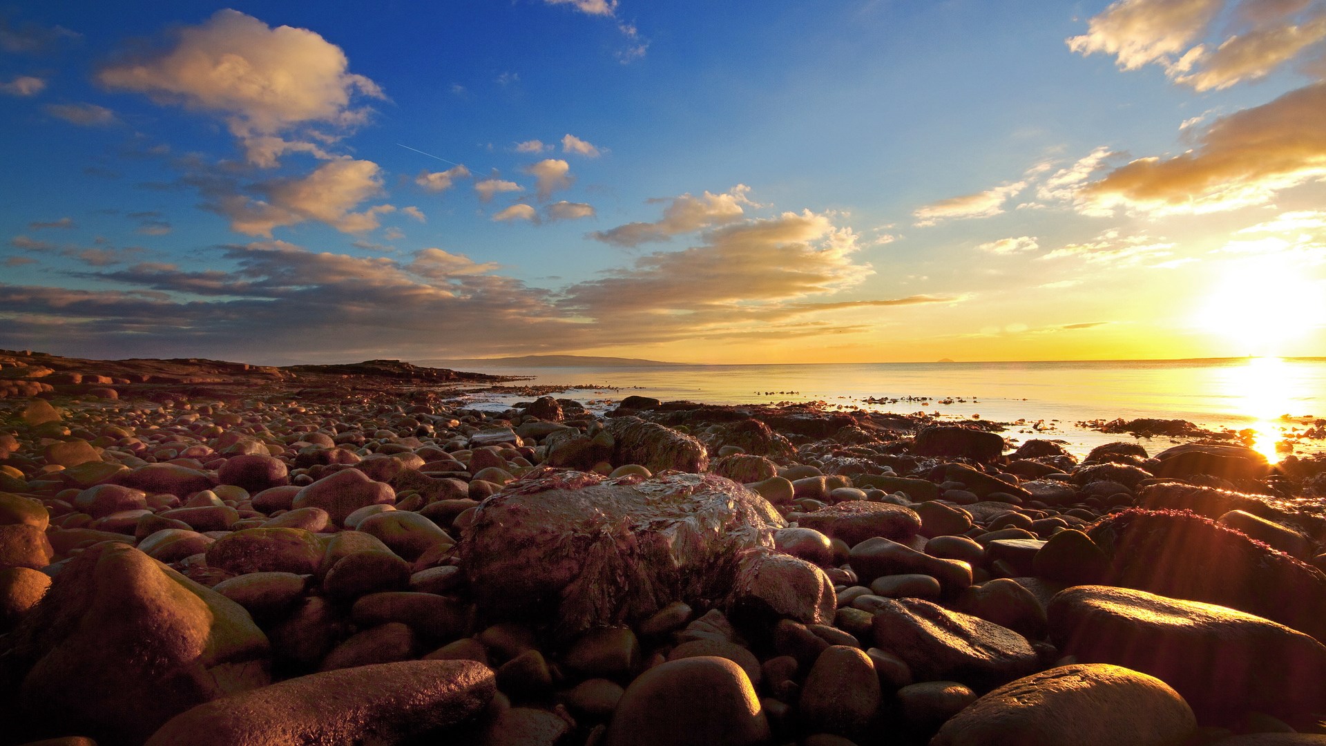 Rocky beach at sunset with ocean and clouds HD Wallpaper