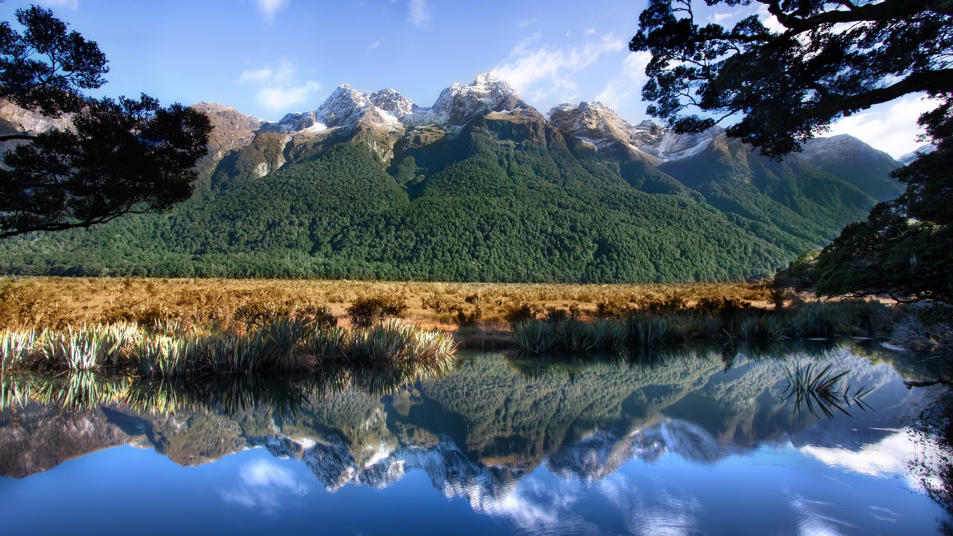 Snow-capped mountains reflected in a calm lake HD Wallpaper