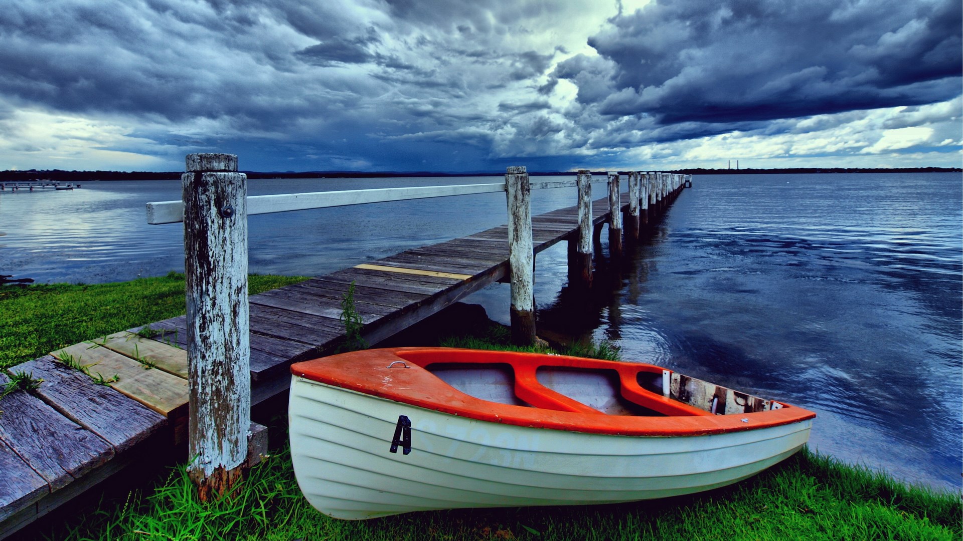 Boat by a wooden pier under stormy clouds HD Wallpaper